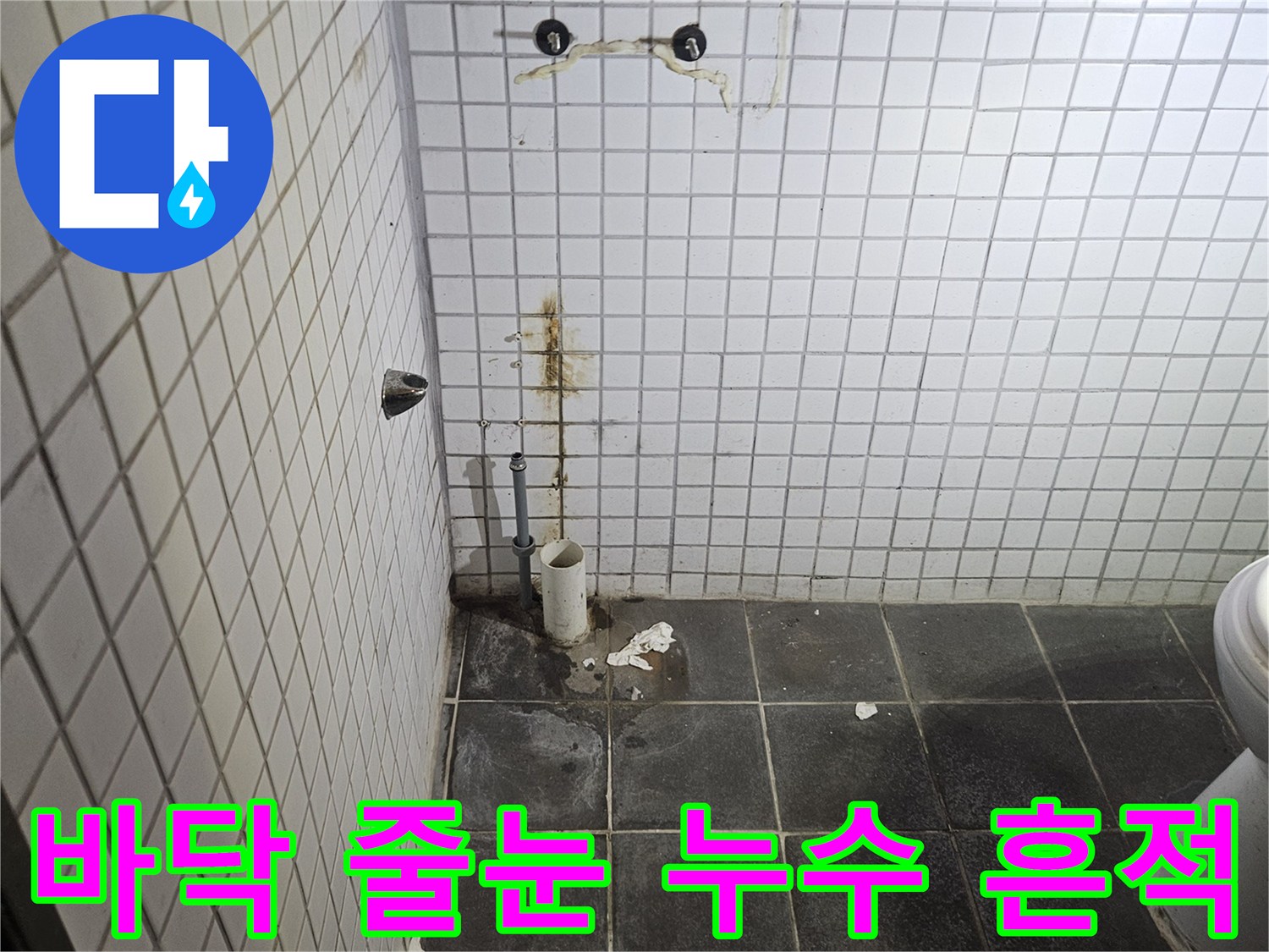 세면대 제거된-욕실 내부에서-바닥 타일의-줄눈 손상과-누수 흔적을-자세히 살펴보는-누수 전문가의-모습