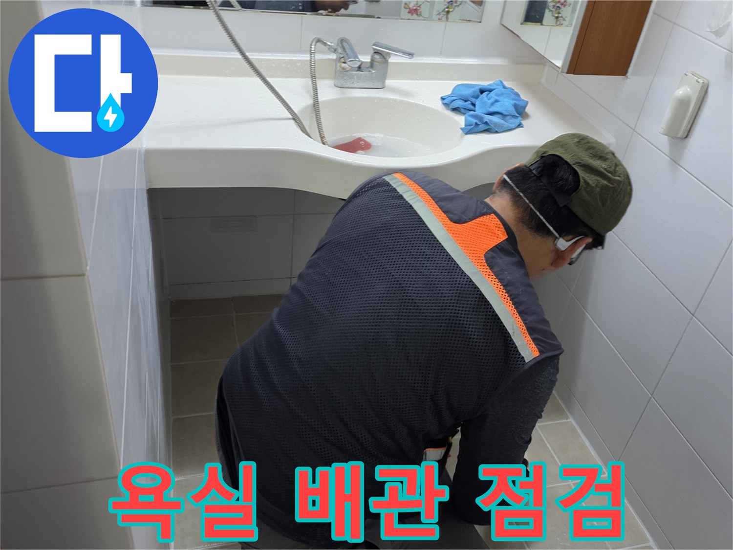 세면대 하단부의 배관 연결 상태와 타일 틈새를 조사하는 장면입니다