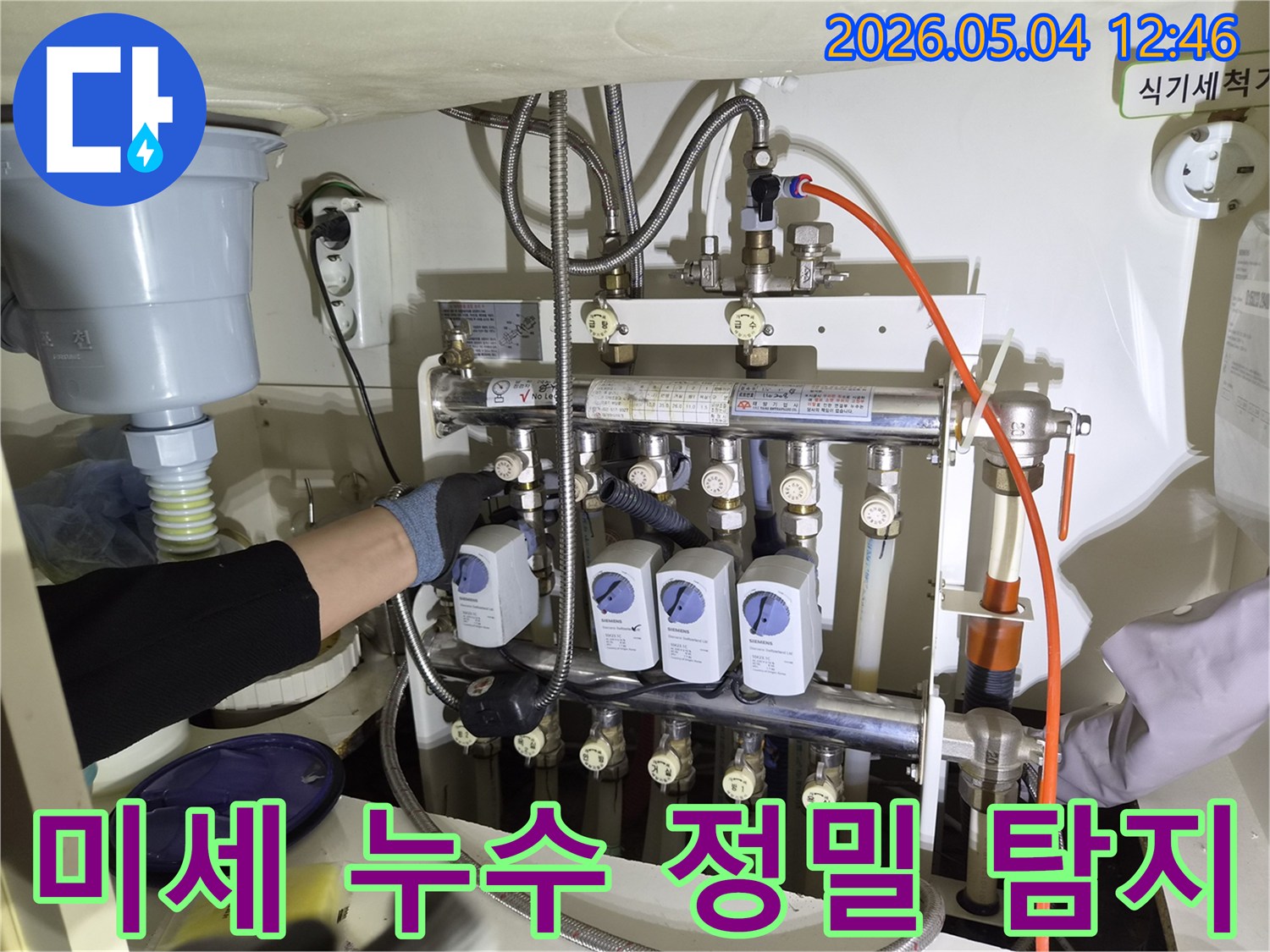 누수 엔지니어가-성동구 금호동에서-미세 누수를 정밀하게 탐지하기 위해-보일러 분배기에 장비를 연결하는 작업