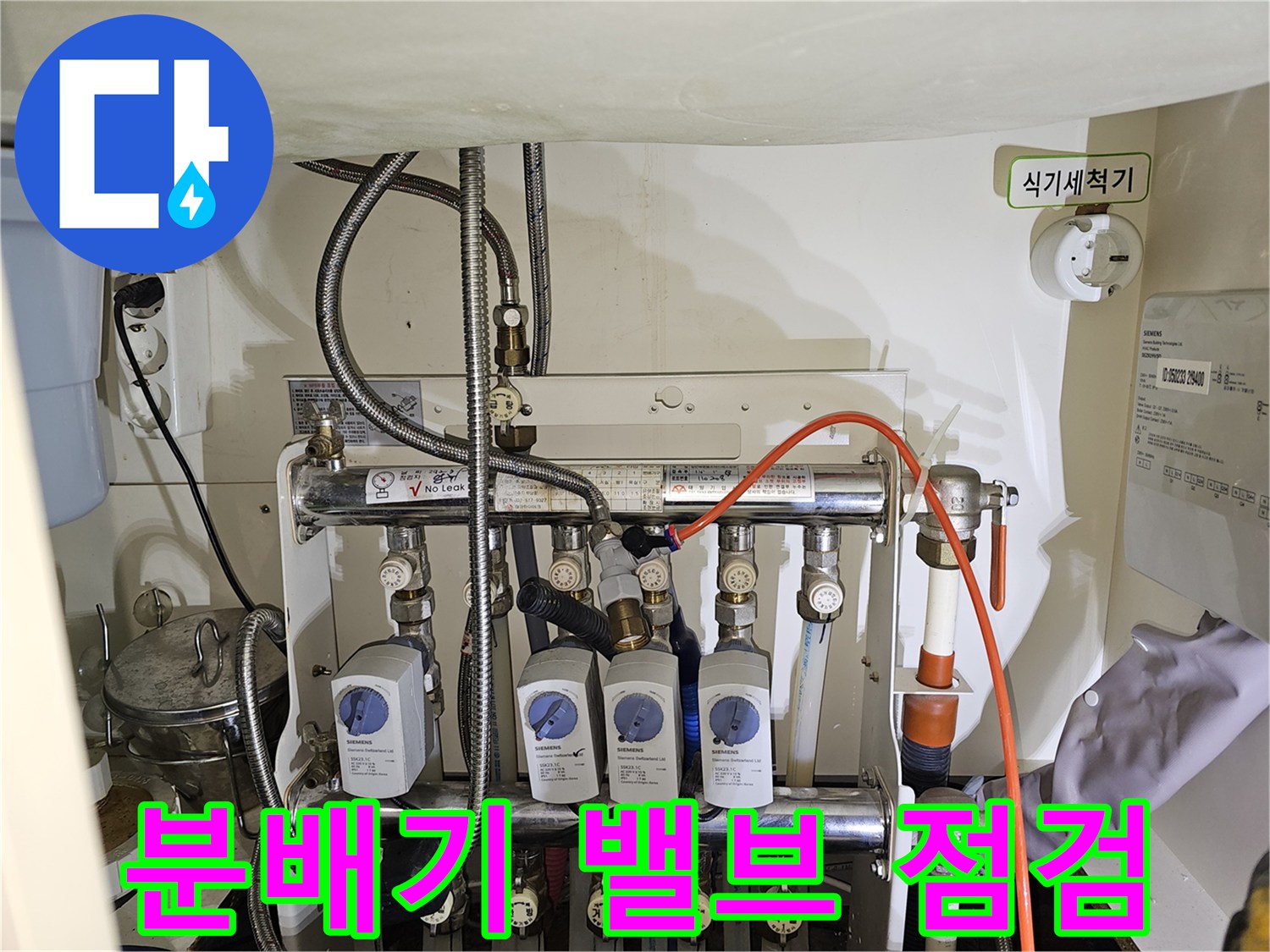 싱크대 하부에 배치된 분배기 밸브와 연결 배관의 모습