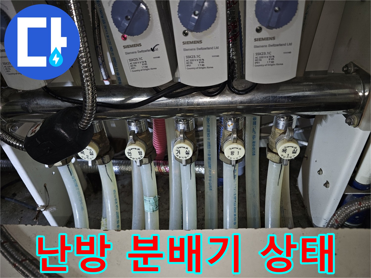 여러 개의 밸브가 연결된 난방 분배기의 복잡한 배관 구조를 보여줍니다.