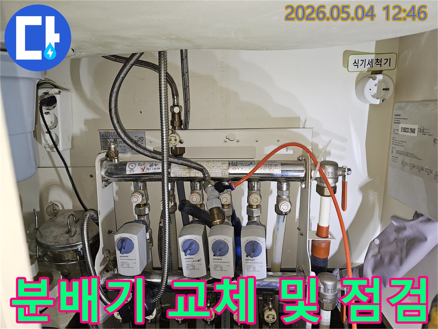 이 이미지는-금호동 아파트에서-노후된 보일러 분배기를-새로운 제품으로 교체하고-누수 여부를 점검하는-전문가의 작업 현장입니다