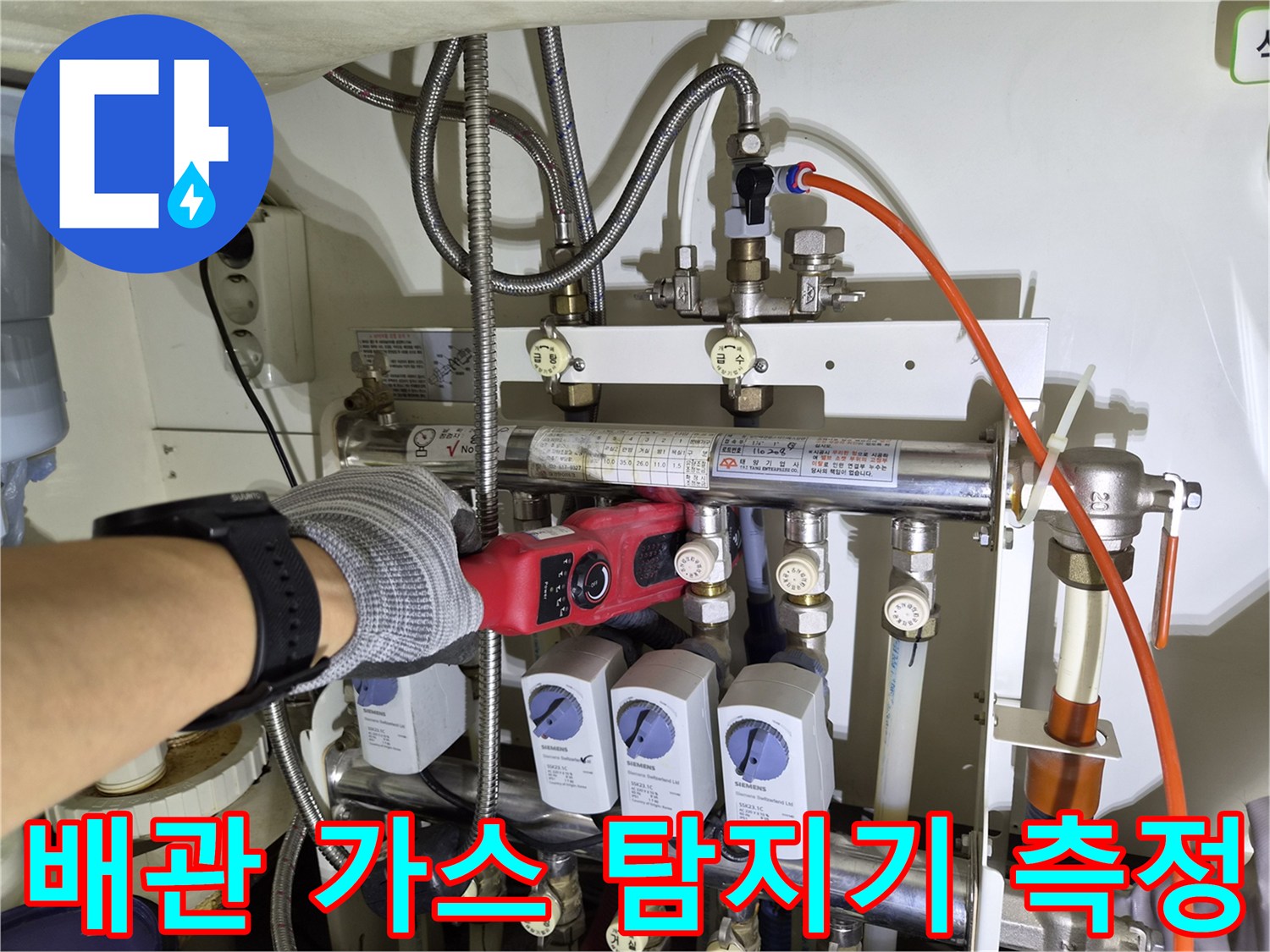 전문-장비를-사용하여-분배기-하단의-배관-누수-지점을-찾아내는-엔지니어의-손길