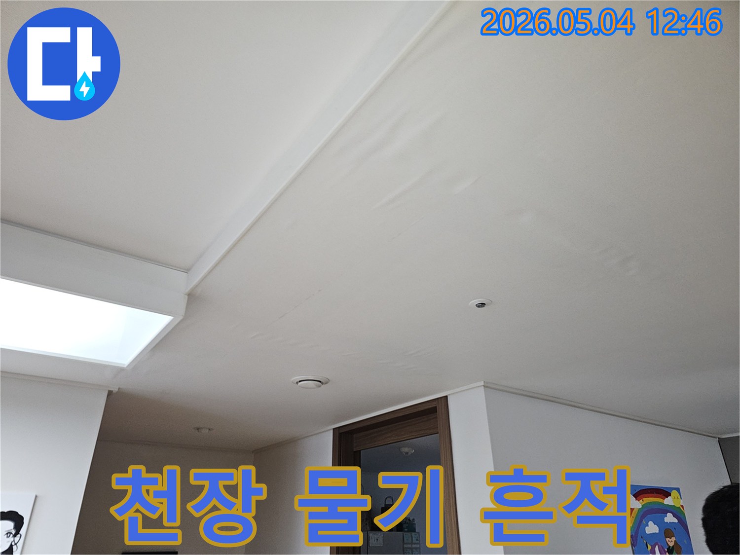 천장에 물이 스며들어-생긴 물기 흔적과-벽지 손상을-보여주는 사진입니다