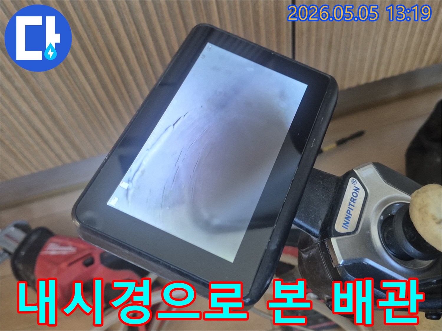 이 이미지는-누수 탐지 전문가가-배관 내시경 장비를-사용하여-배관 내부의-손상된 부분을-정밀하게-확인하는-과정을-담고 있습니다
