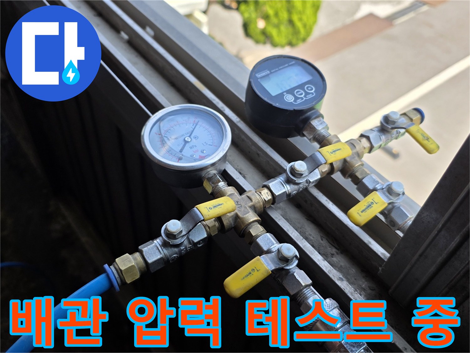 금속 배관과 연결된 압력 측정 장치 및 노란색 밸브 손잡이