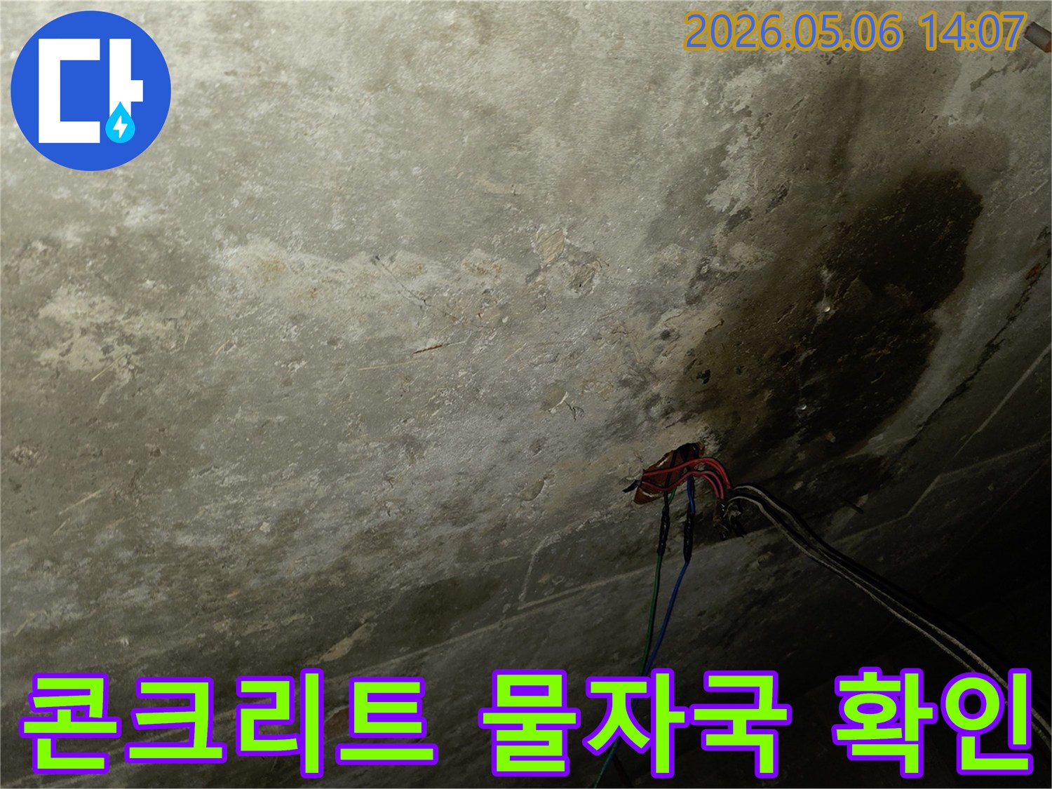 이 사진은 오래된 천장 콘크리트 표면에 나타난-심각한 물자국과-노출된 전선들을 보여줍니다.