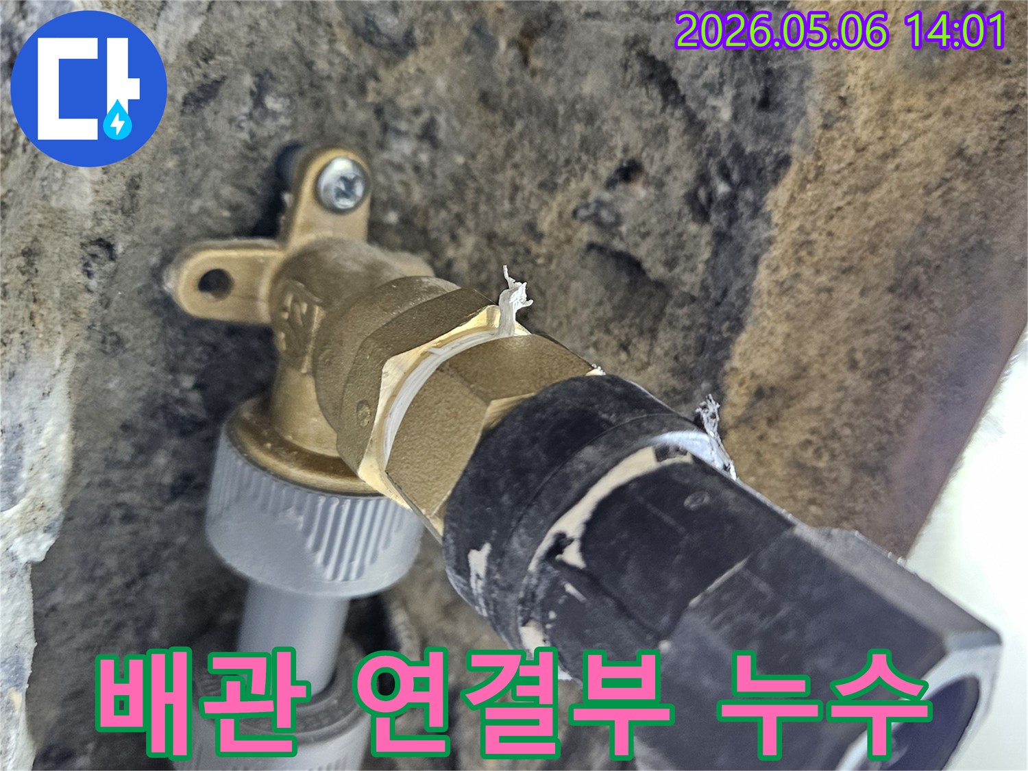 이 이미지는-콘크리트 벽에-설치된-수도관 밸브의-연결부위에서-누수가-발생한-현장을-보여줍니다.
