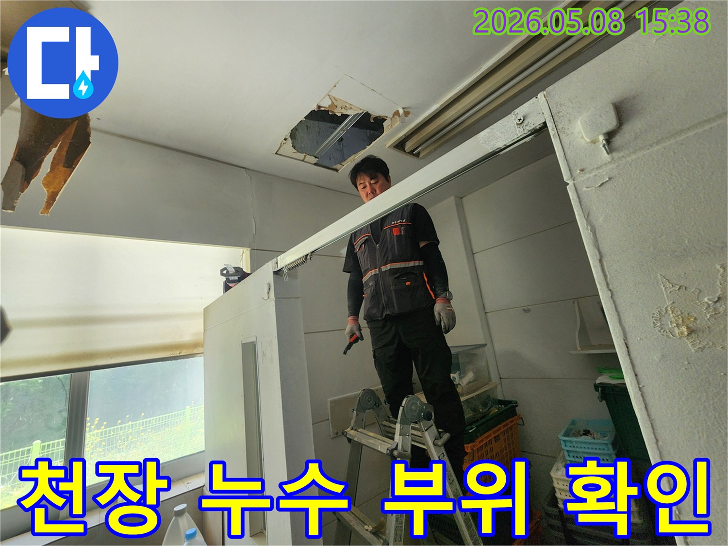 숙련된 엔지니어가 사다리를 딛고-천장 손상 부위를-면밀히 관찰하고 있습니다