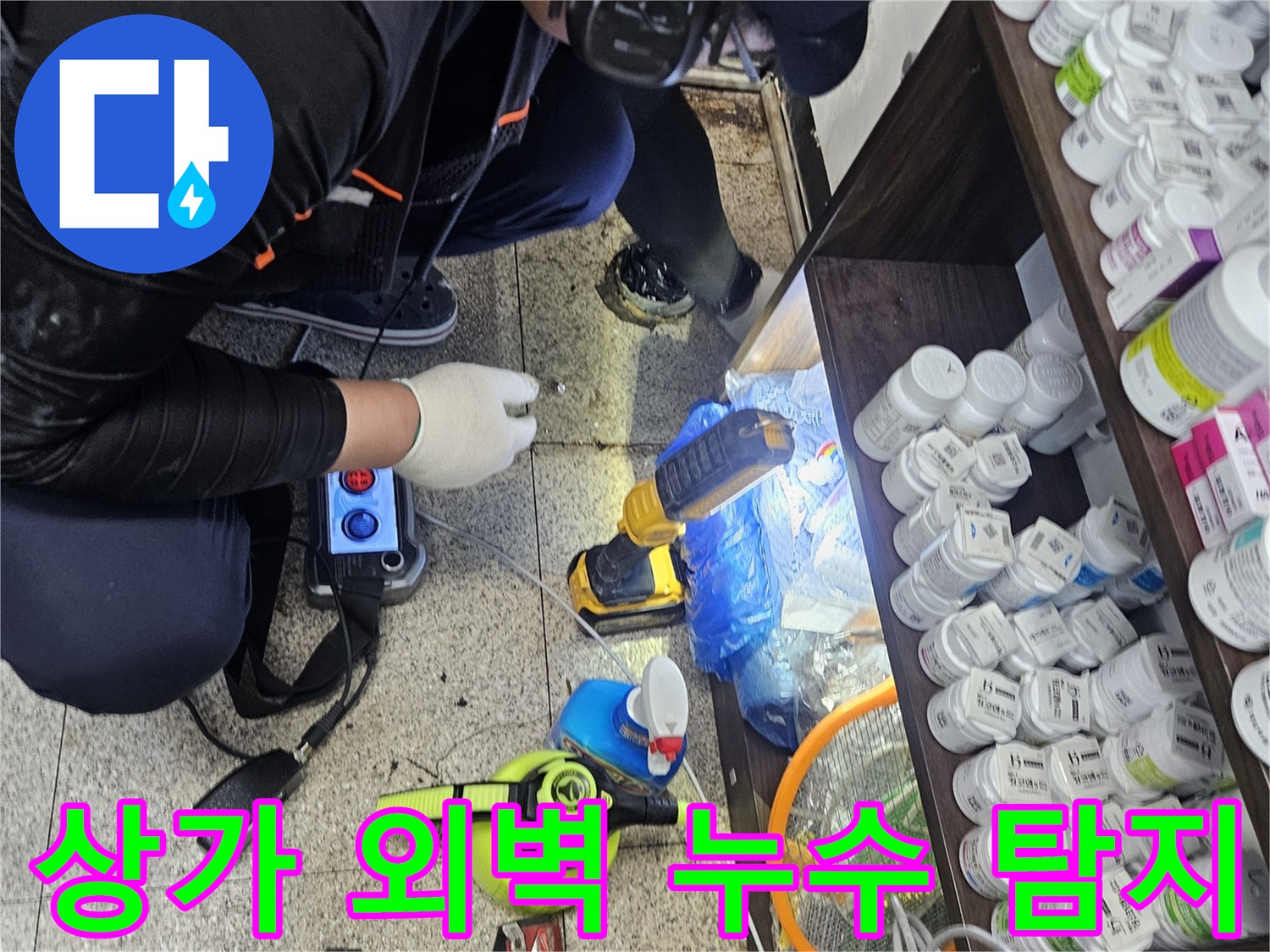 전문 엔지니어가-상가 건물 외벽 배관에서-누수음을 듣기 위해-청음 탐지기를 사용하는-정확한 진단 과정입니다