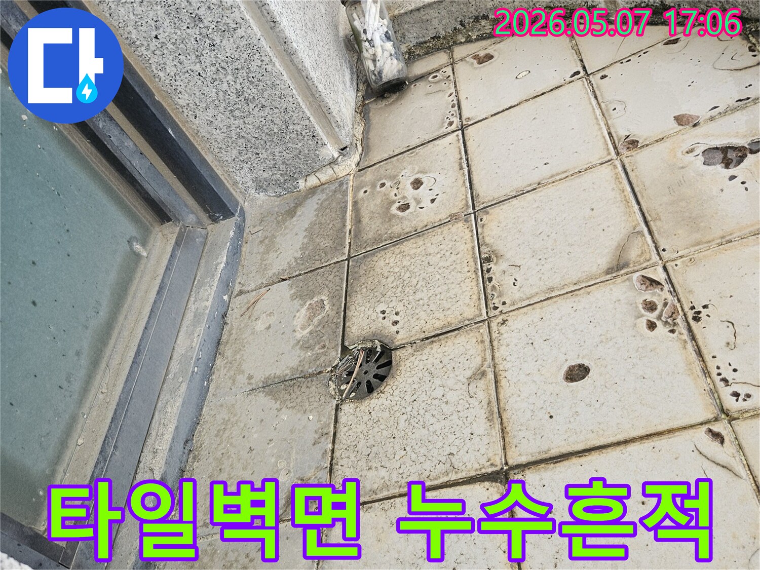 이 이미지는-오래된 타일 벽면에서-누수가 발생하여-물때와 손상이 진행된 모습을-선명하게 보여줍니다