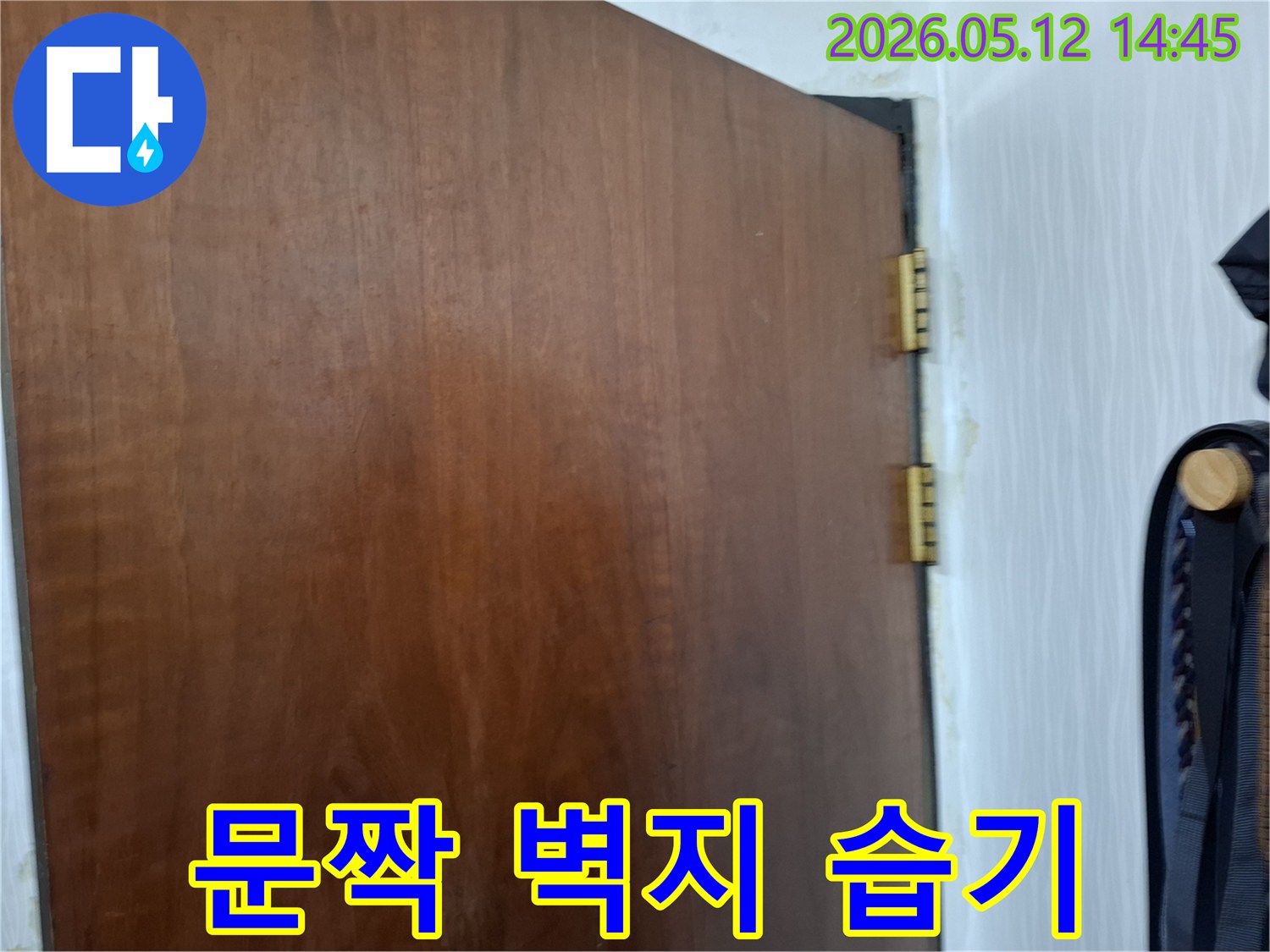 문짝-옆-벽지에-누수로-인해-발생한-습기와-변색을-자세히-보여주는-사진입니다