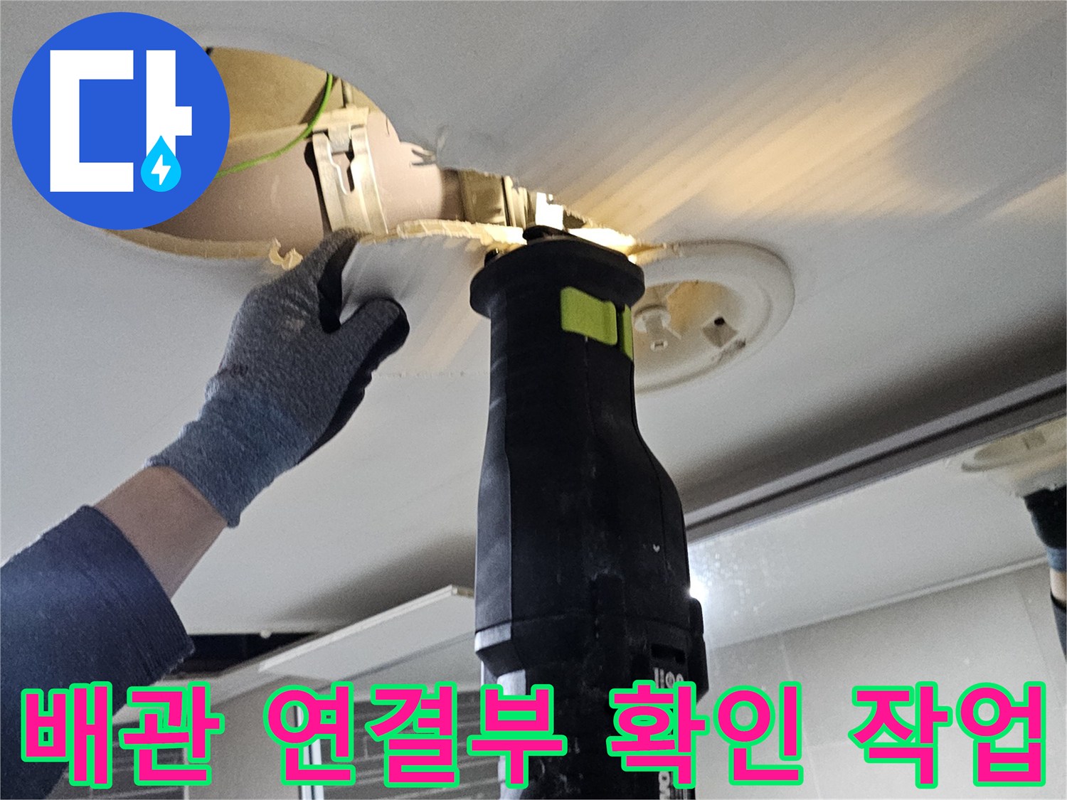천장 내부-배관 부속의 누수 여부를 확인하기 위해 드릴로 작업 중인 장면