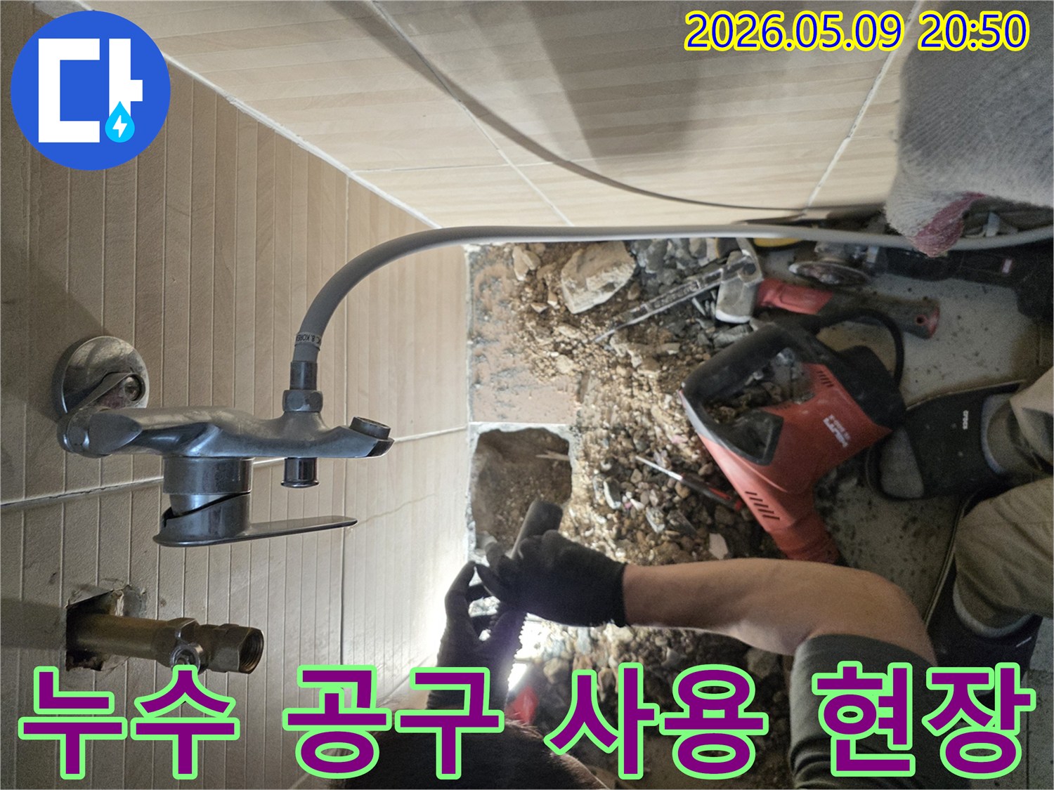 이 이미지는-성남 수정구의 한 빌라에서-욕실 누수 문제를 해결하기 위해-전문가가 특수 공구를 사용하여-바닥을 개방하고-손상된 배관을 보수하는-현장을 보여줍니다.
