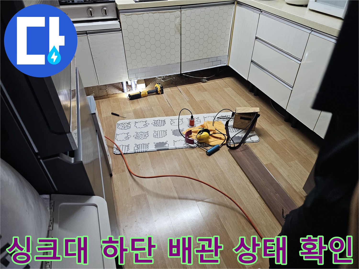 싱크대 아래쪽 노출된 배관과 주변 바닥의 모습