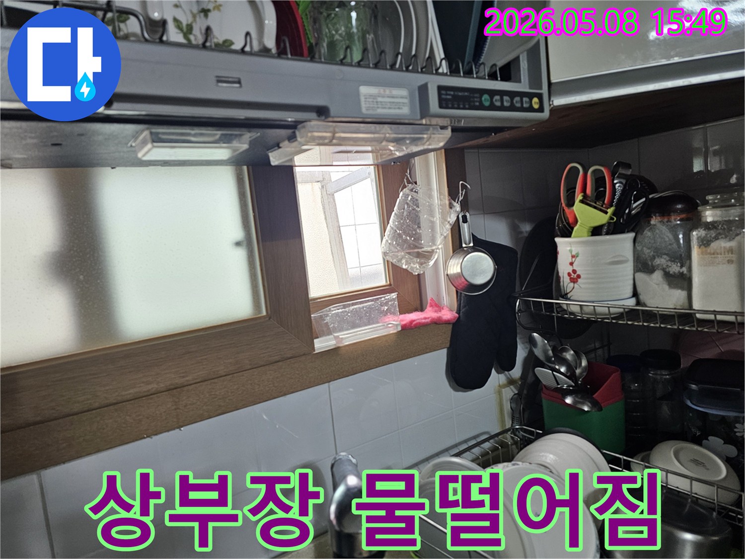 주방 싱크대 상부장 아래에서-물이 계속 떨어지고 있는-긴급 누수 현장 이미지