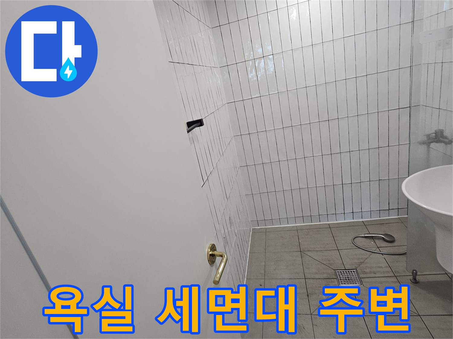 금색 수도꼭지가 설치된-세면대와 타일 벽면 전경
