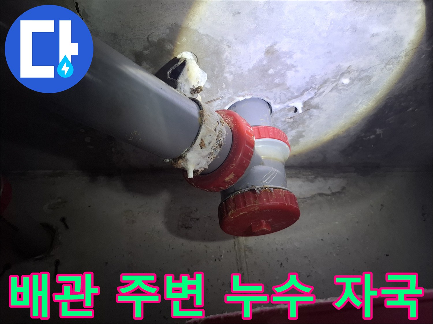 오수관 연결 부속 주위에 맺힌 하얀색 누수 잔여물