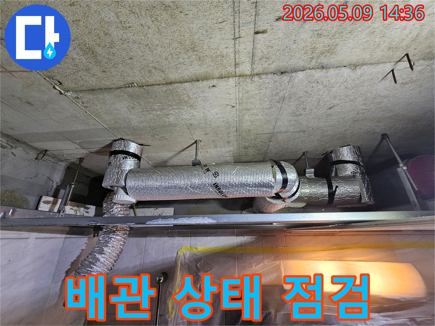 천장에 설치된 단열 배관의 전반적인 상태와-주변 콘크리트의 이상 유무를 점검하는 현장 사진입니다.