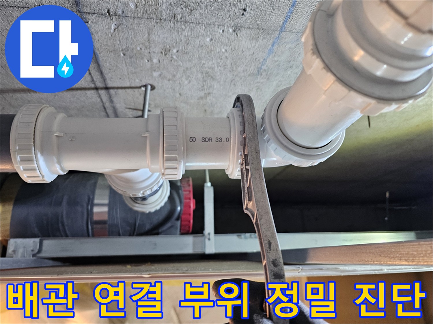 하수 배관-연결 부속의 물샘 확인을 위한 렌치 사용 장면