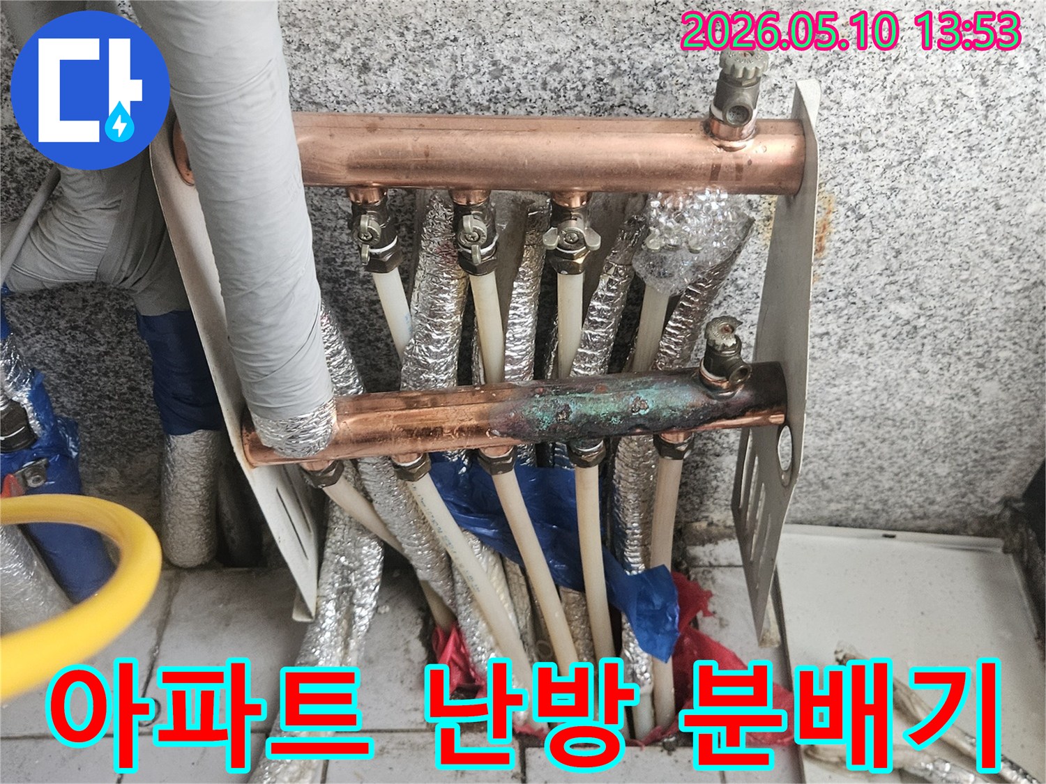 아파트 난방 시스템에 설치된-오래된 동파이프 분배기가-부식되고-보온재가 손상된-모습을 보여주는 이미지입니다.