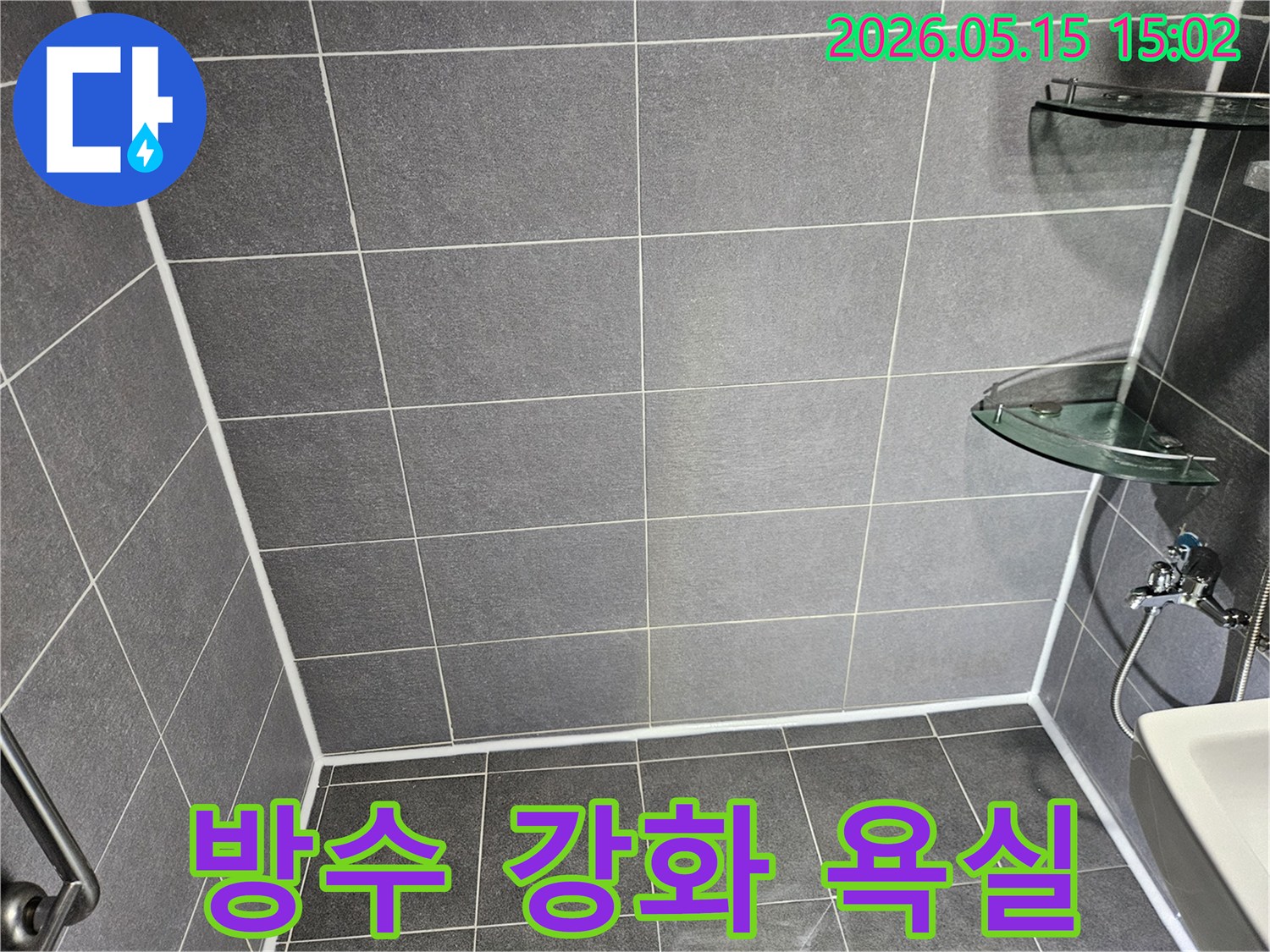 누수 문제 해결을 위해-새롭게 시공된-욕실의 타일과-하얀 줄눈 마감 상태