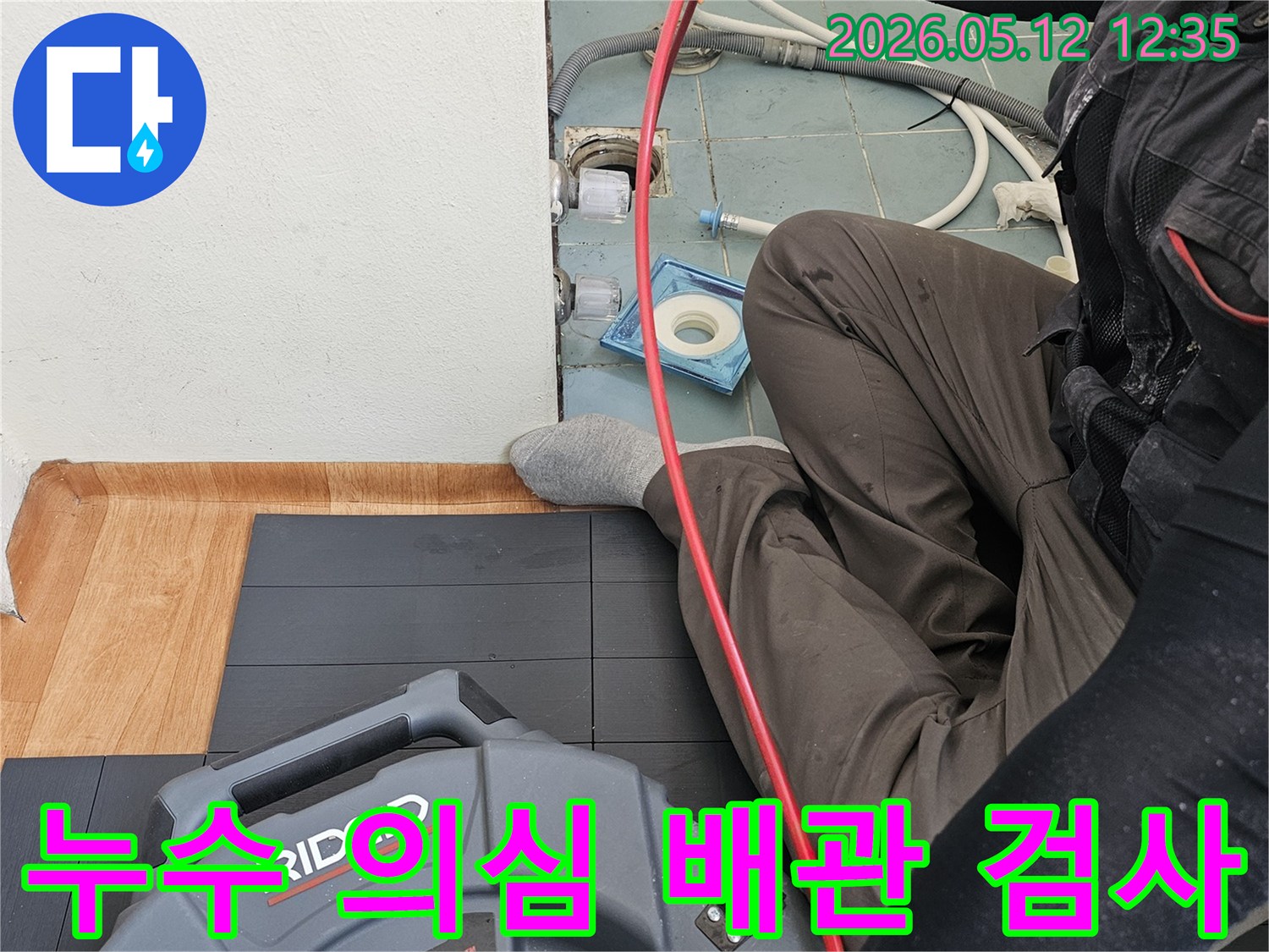 누수 전문 엔지니어가-누수 의심 지점을 확인하고자-배관 내시경 장비를 이용해-정밀 검사를 진행하는 모습