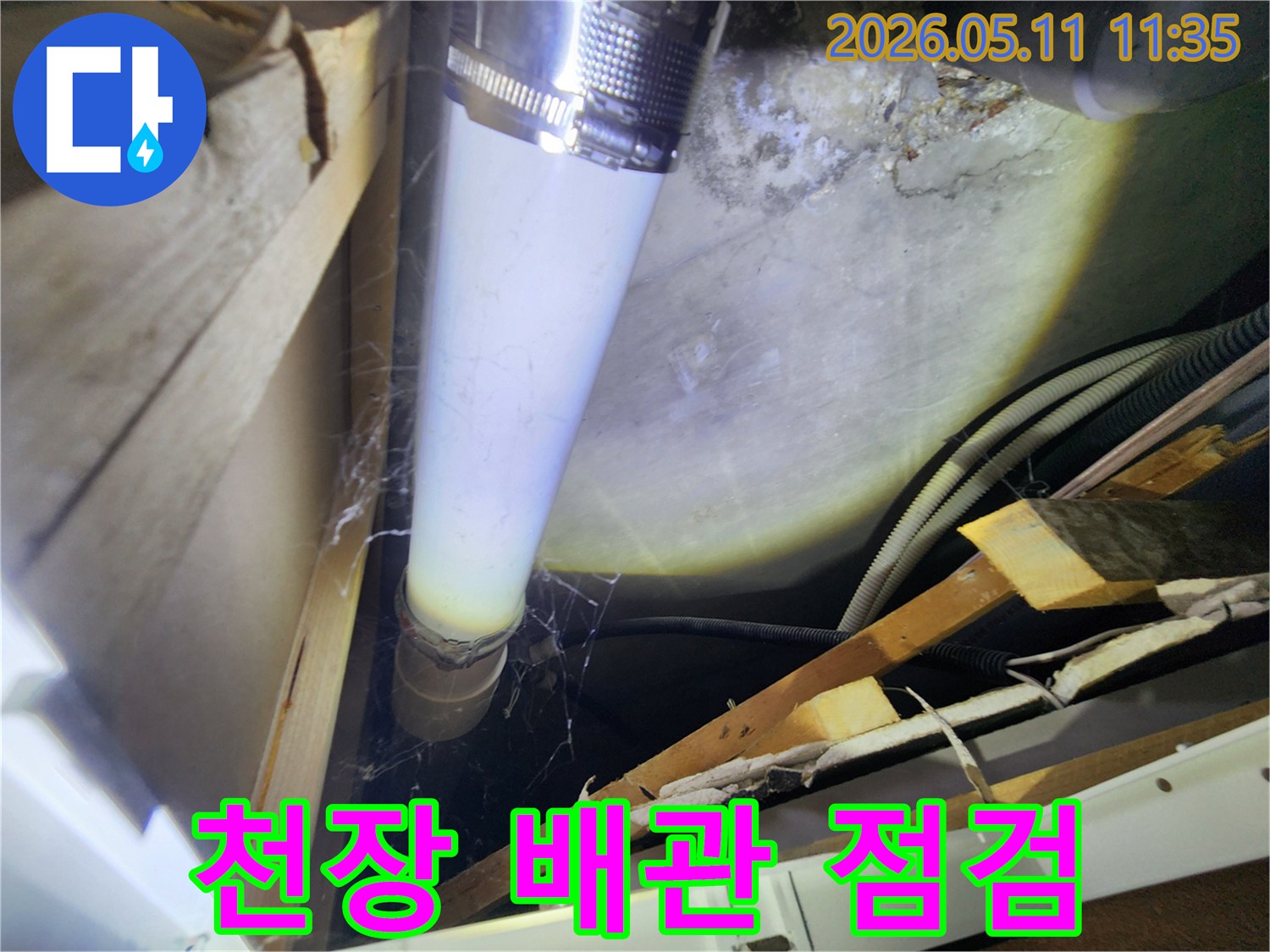 천장 내부의 배관에서-발견된 물기 자국과-주변 습기 흔적을-면밀히 조사하는 장면입니다.