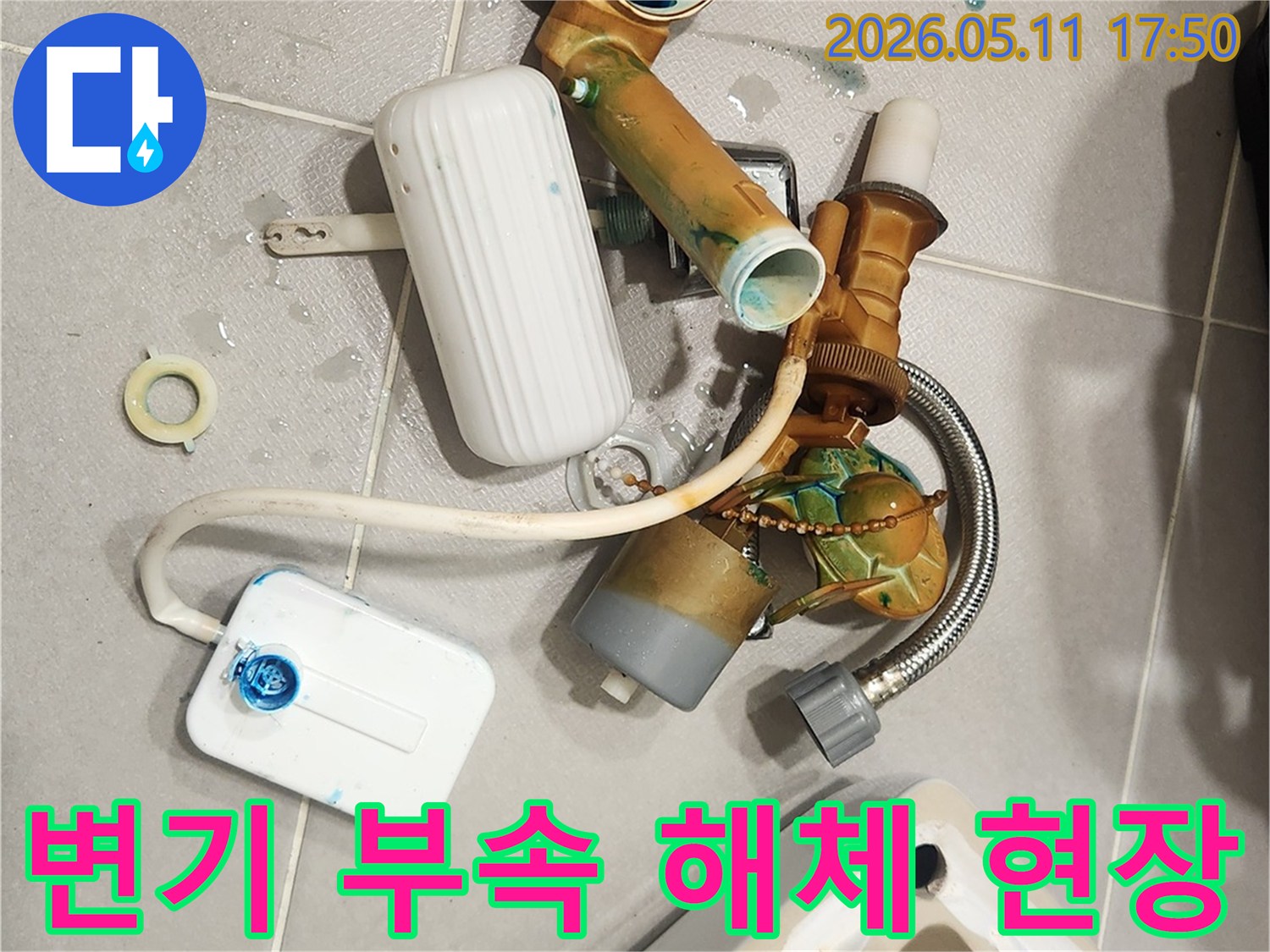 안방 변기에서 발생한 물샘 문제를 해결하기 위해-오래된 변기 부속들이 해체되어 바닥에 놓여 있는 모습입니다-새 부품으로 교체하여 변기를 수리할 예정입니다