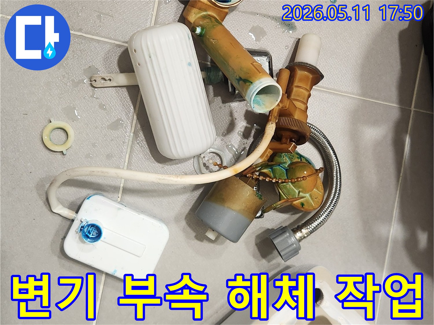 안방 변기에서 발생한 물샘 문제를 해결하기 위해-오래된 변기 부속들이 해체되어 바닥에 놓여 있는 모습입니다-새 부품으로 교체하여 변기를 수리할 예정입니다
