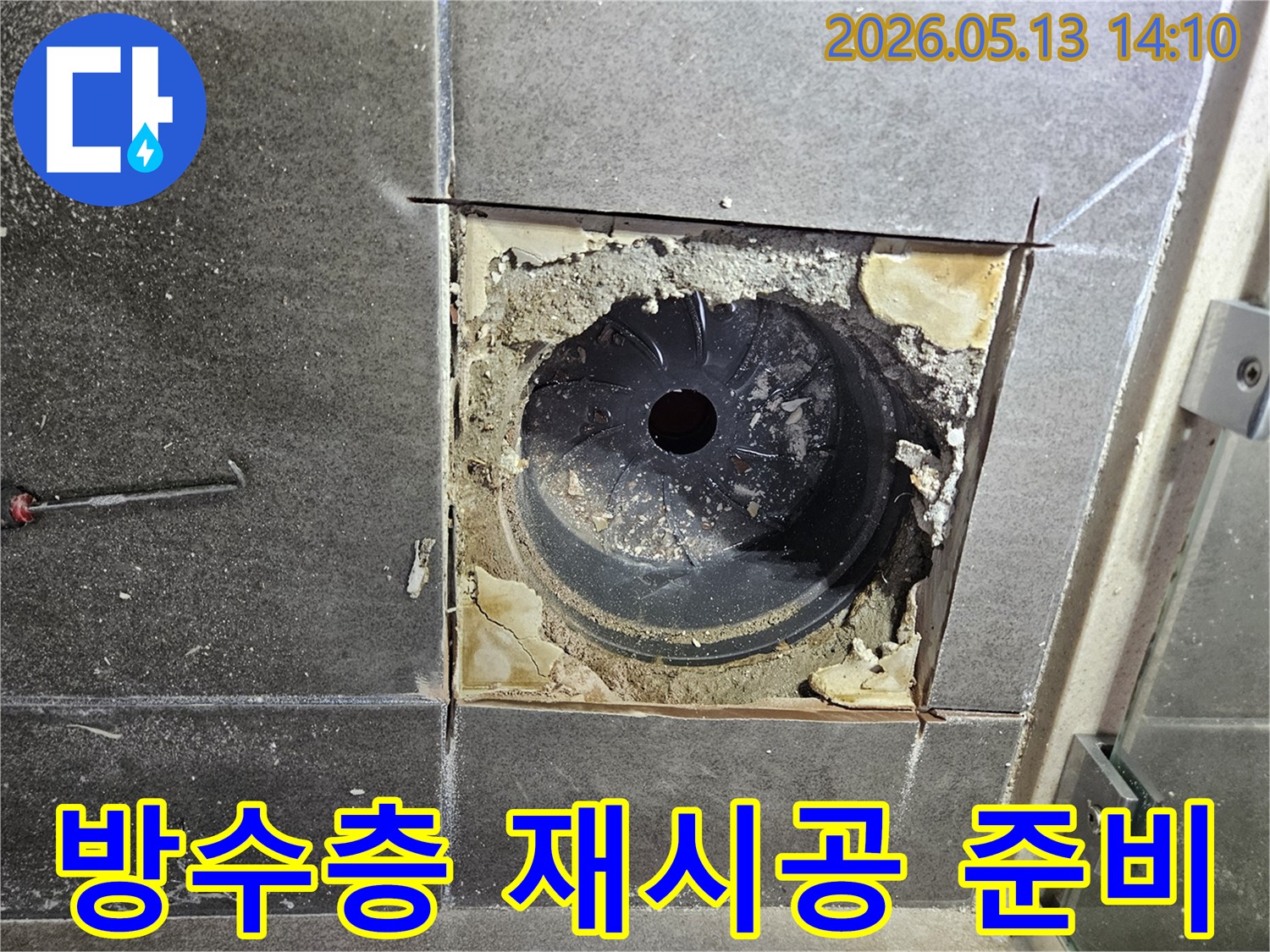욕실 바닥 누수 해결을 위해-배수구 주변의 낡은 방수층을 제거하고-새로운 방수층을 재시공하기 위한 준비를 하는 모습입니다
