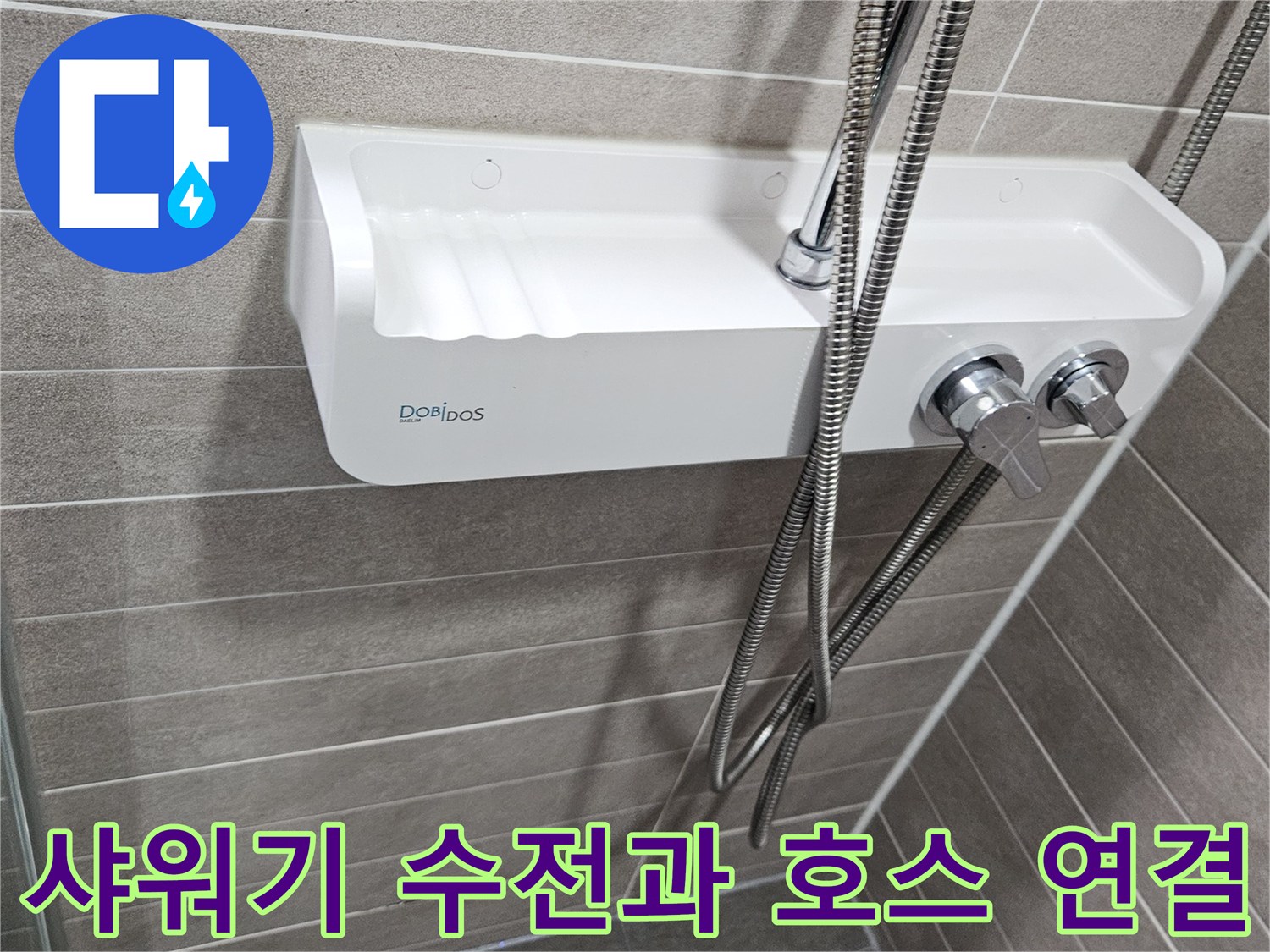 욕실 벽면 타일 사이에 설치된 샤워기 수전과 금속 호스 이미지입니다.