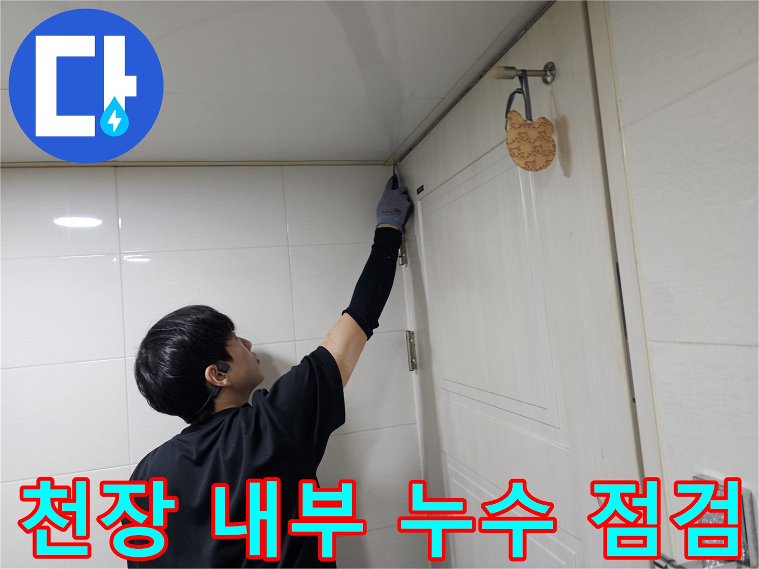 엔지니어가 손을 뻗어 화장실 천장 내부의 물샘 부위를 관찰합니다.