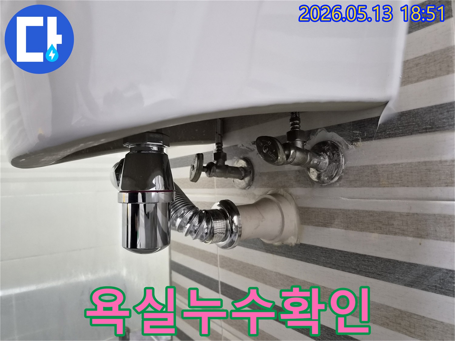 욕실 세면대 하부의-배수 트랩과-급수 밸브의-연결 상태를-점검하여-누수 여부를-판단하는 모습입니다.