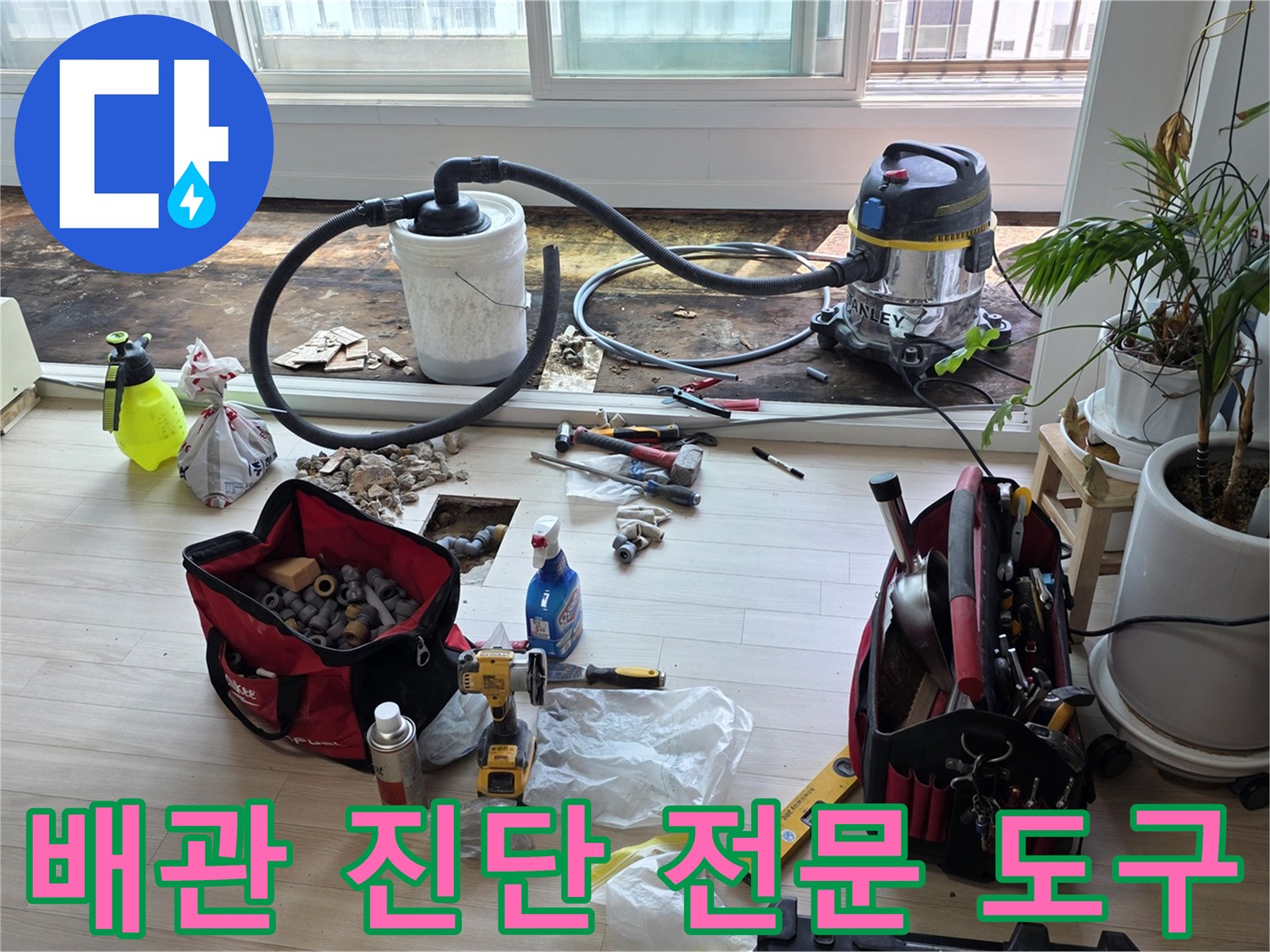 현장에서 사용 중인 가스 탐지기와 청소용 진공 흡입기 및 수공구 세트