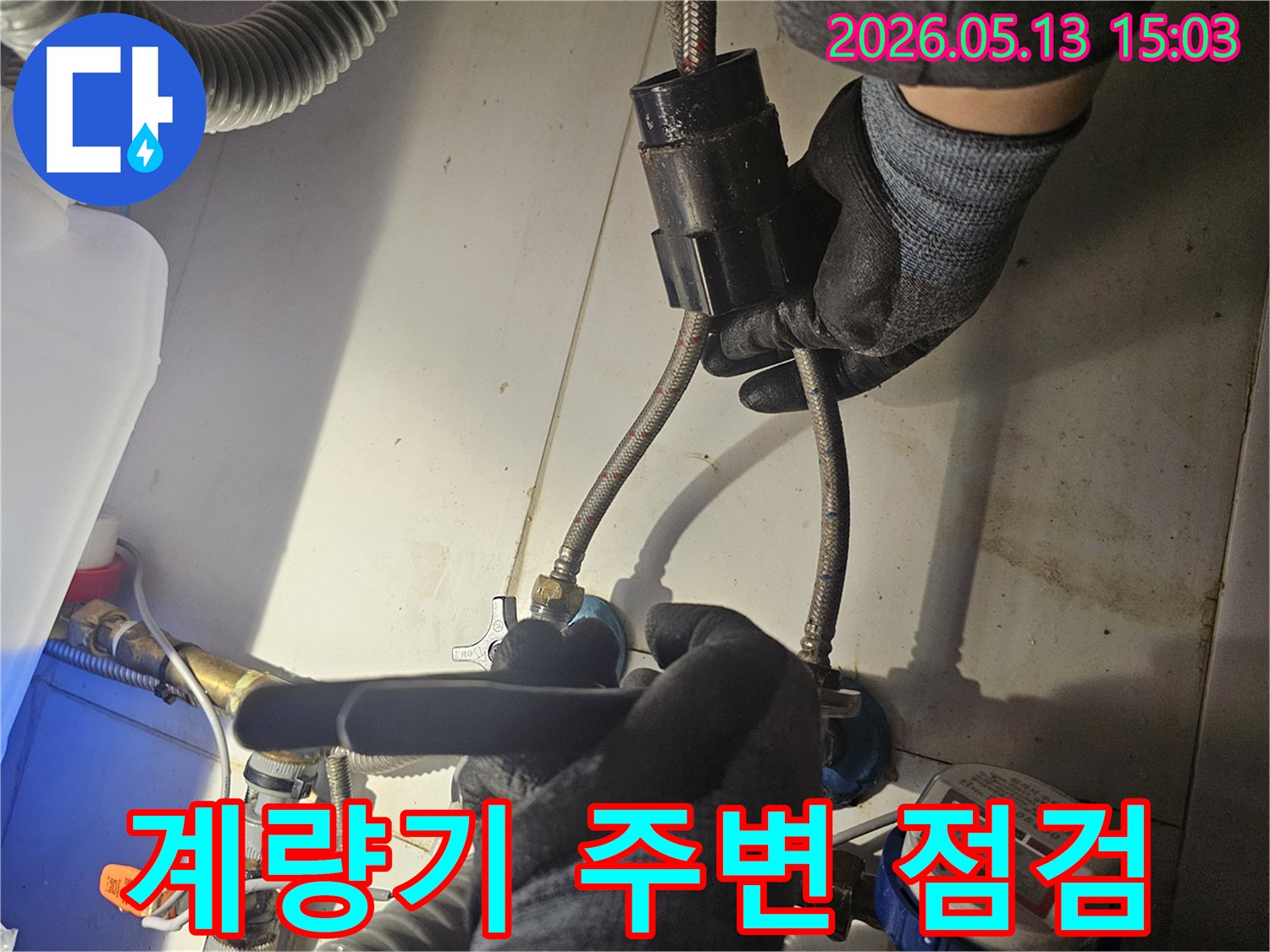 전문 기술자가-수도 계량기 주변의-배관 연결 상태를-꼼꼼하게 점검하며-누수 흔적을-찾아내고 있습니다