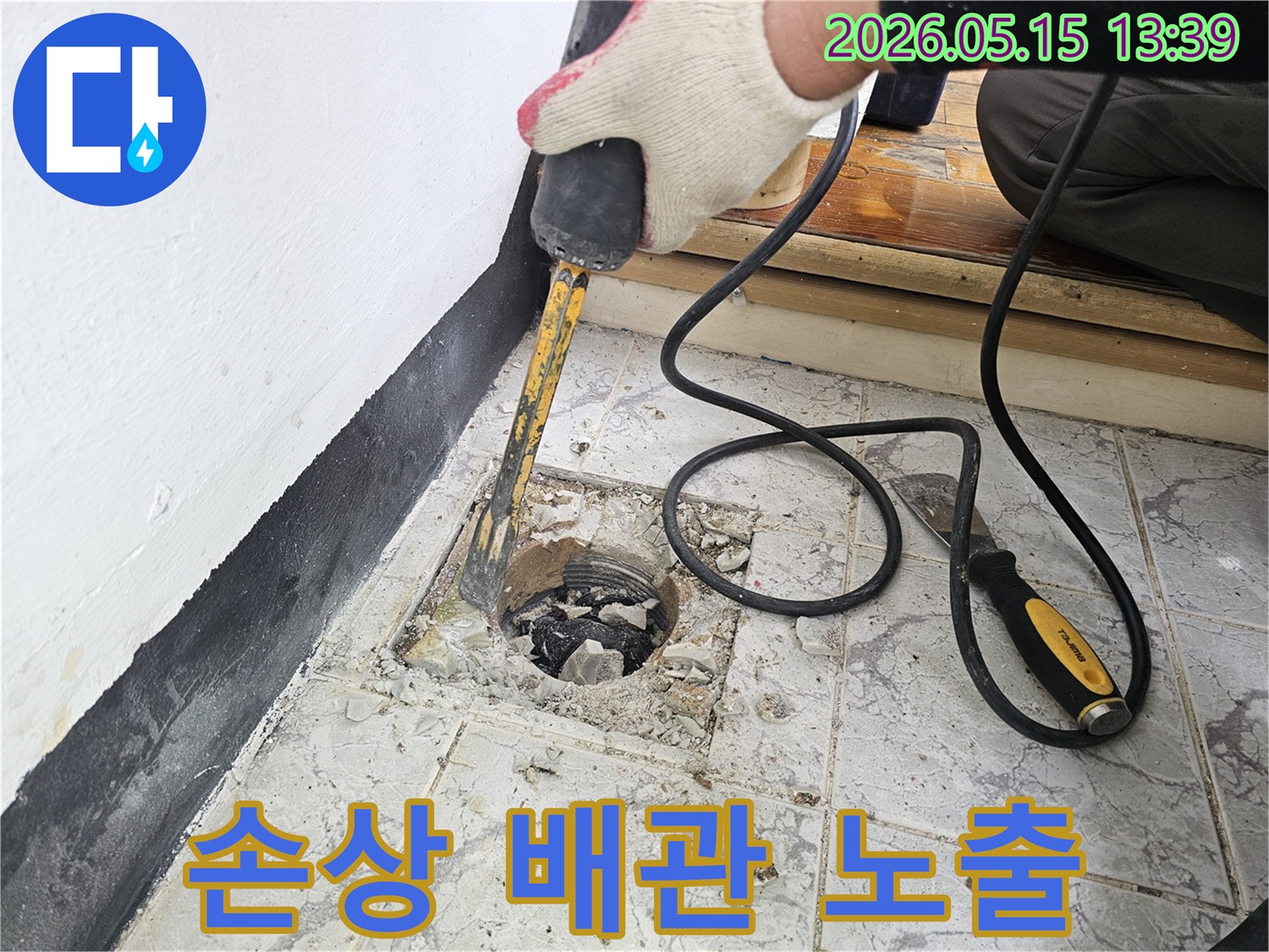 누수 수리를 위해 손상된 배관을 노출시키기 위해 주변 타일을 제거하는 작업