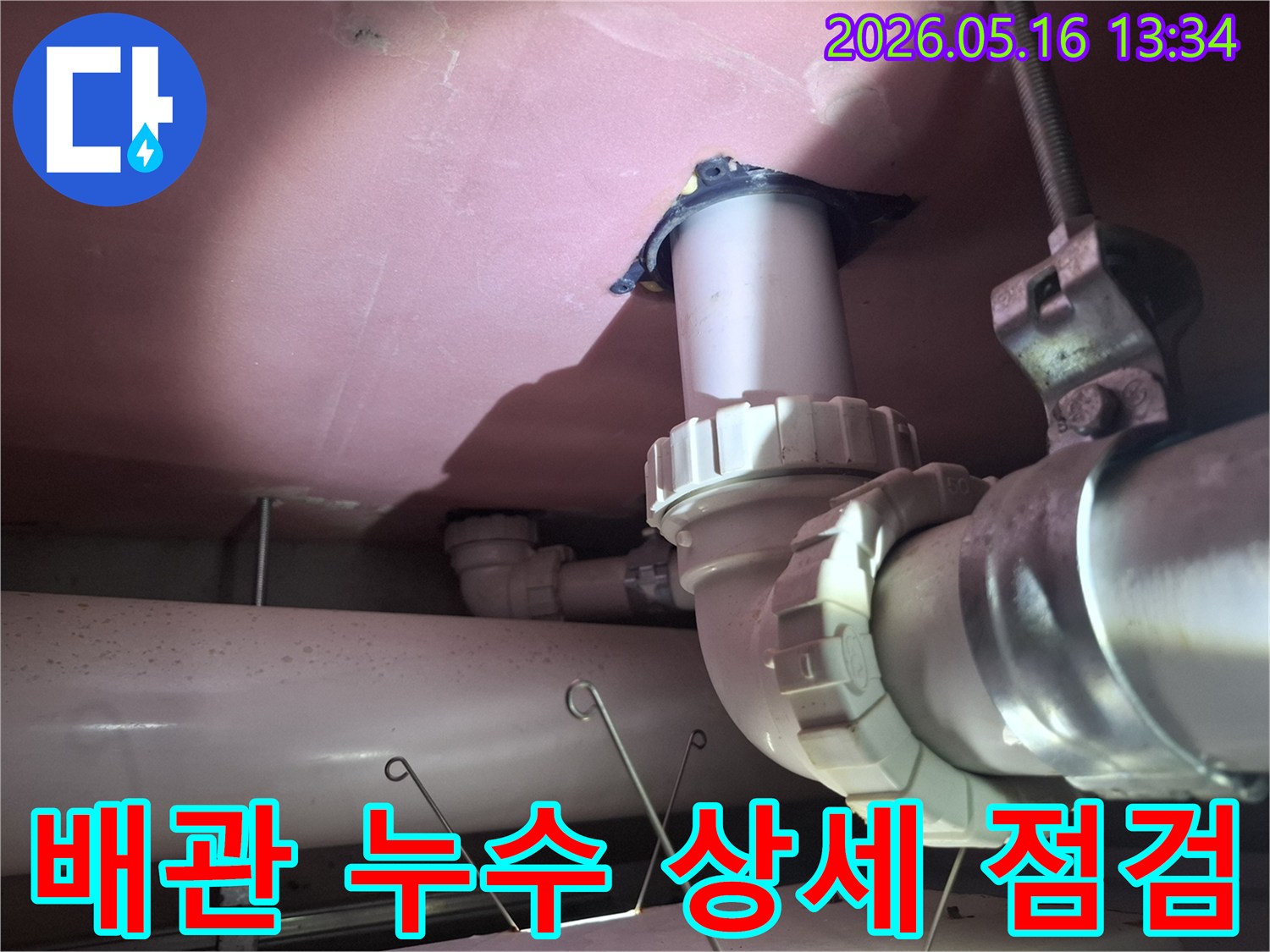 천장 배관의-복잡한 연결부를-수리하기 전-전문가가-상세하게 점검하며-문제의 원인을-파악하는-모습을 담고 있습니다.