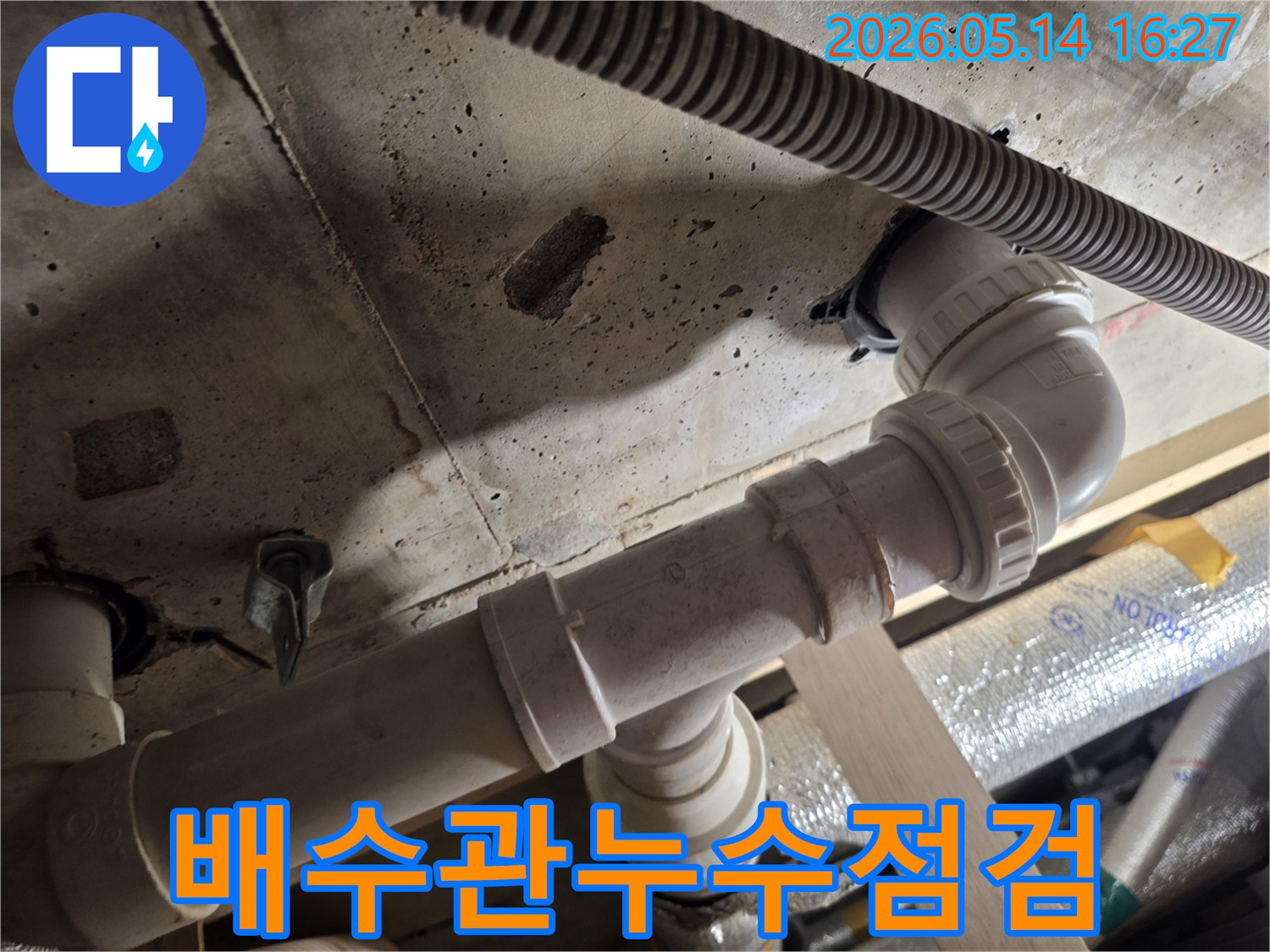 누수-전문가가-천장-배수관의-누수-여부를-세심하게-확인하는-모습