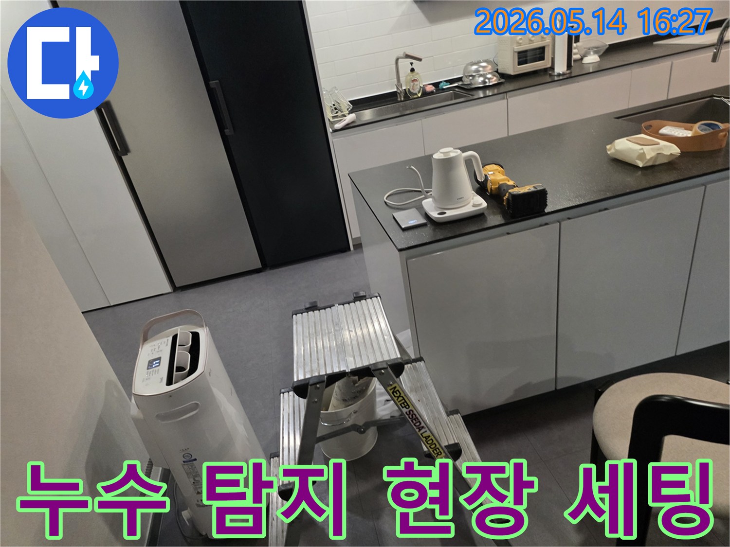 누수 탐지 전문가가-고객님의 주방에서-작업 전-장비 점검과-환경 확인을 하고 있습니다.