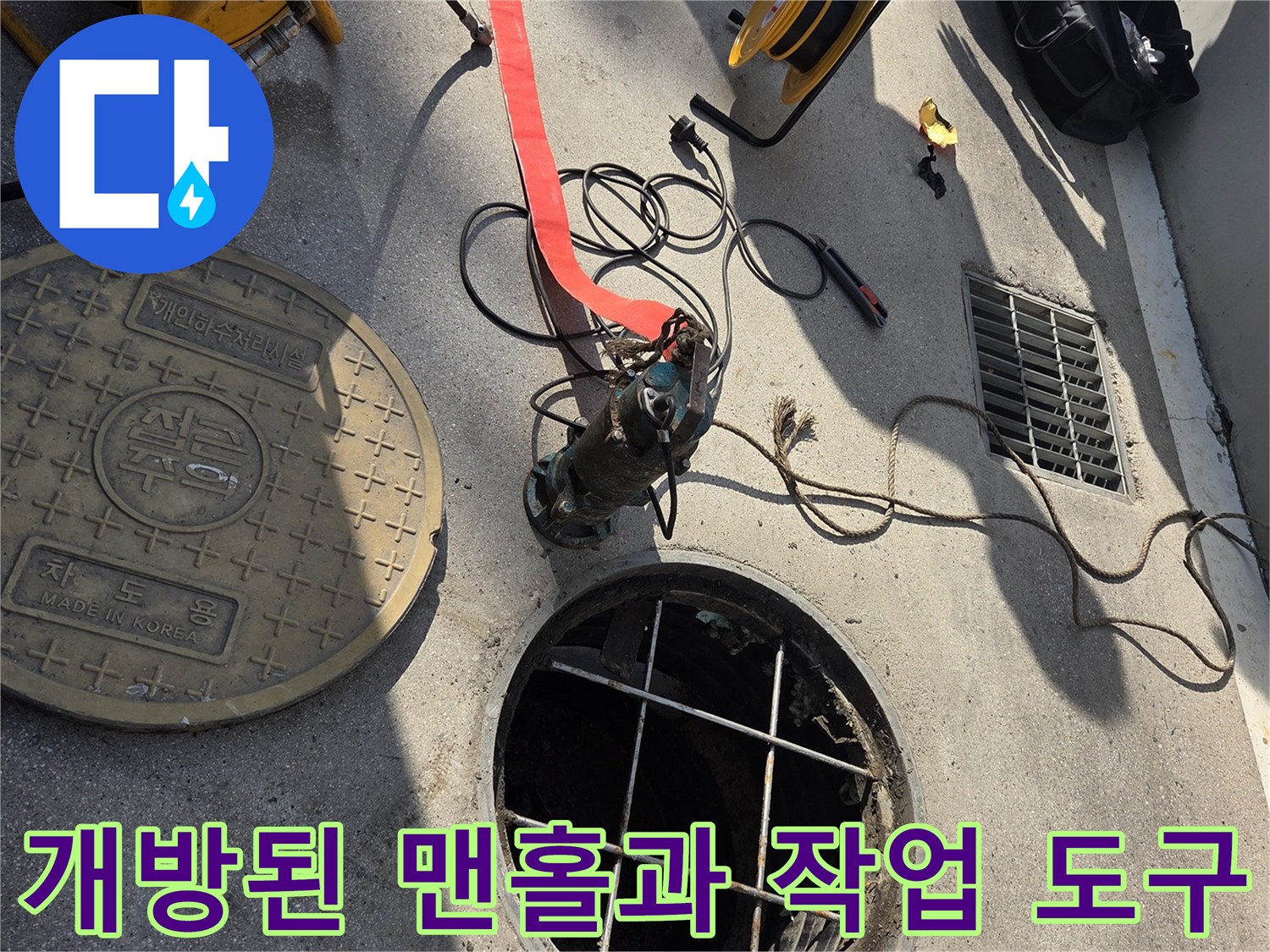 맨홀 내부의 격자 구조물과 주변에 놓인 고압 세척용 릴
