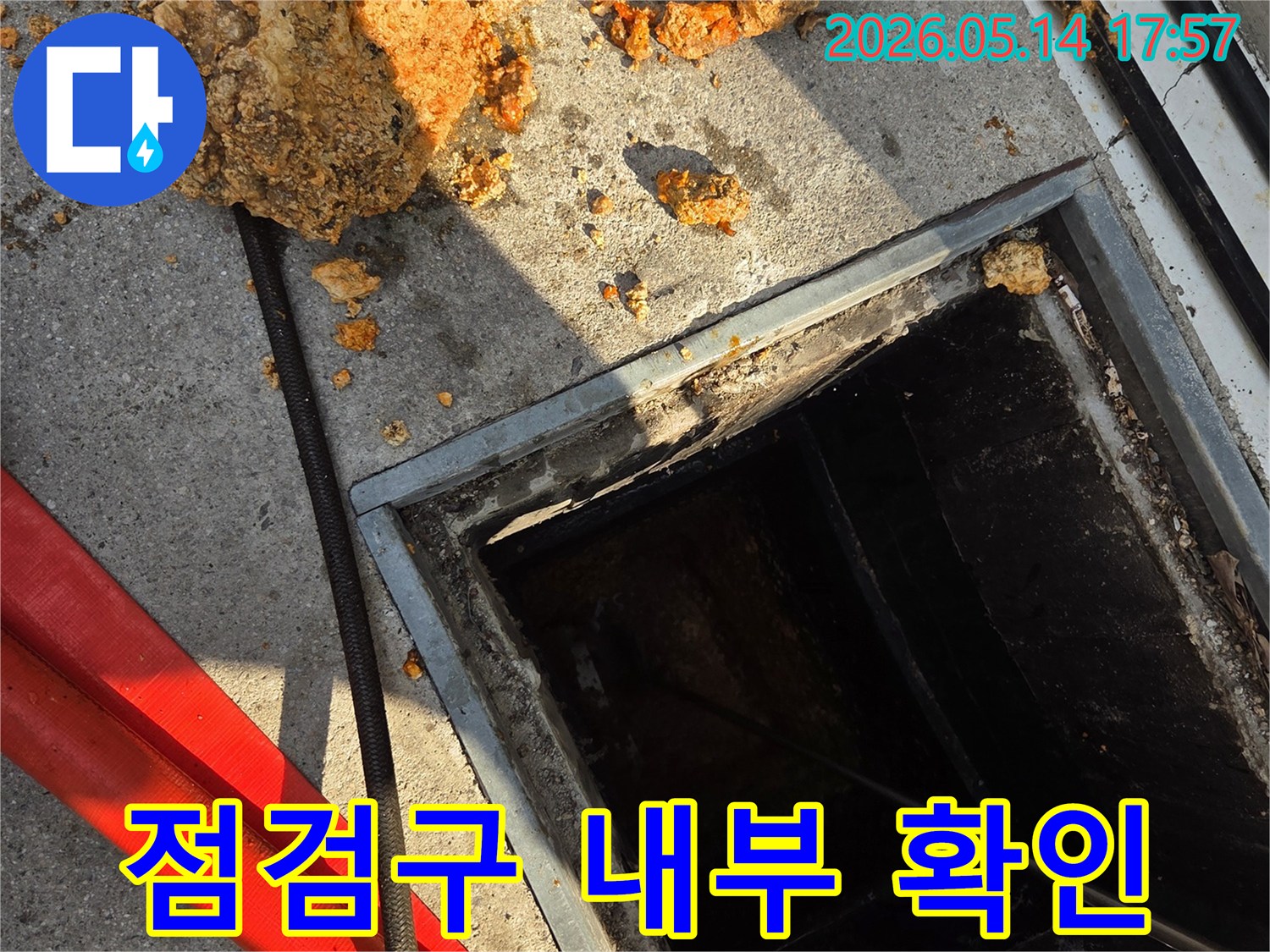 점검구를-통해-배관-내부의-막힘-상태를-확인하고-있는-모습-주변에-제거된-오염물질이-보이는-작업-현장