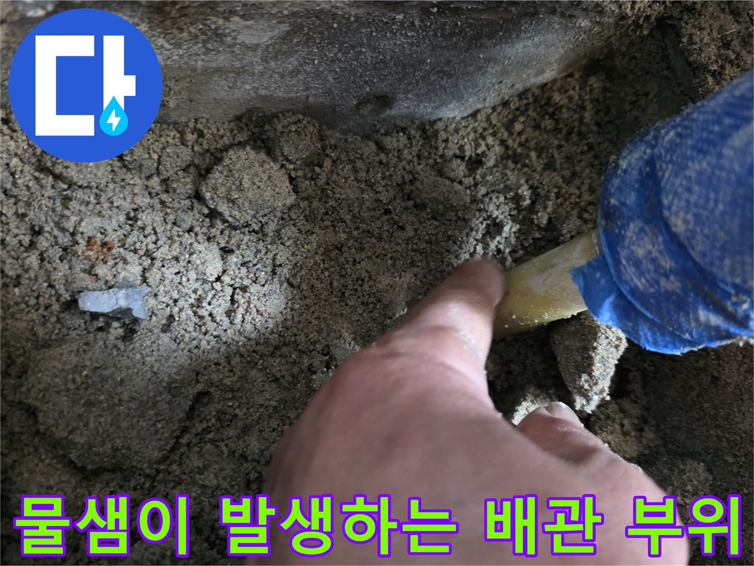 손으로 짚어보고 있는-노란색 배관의 균열 지점