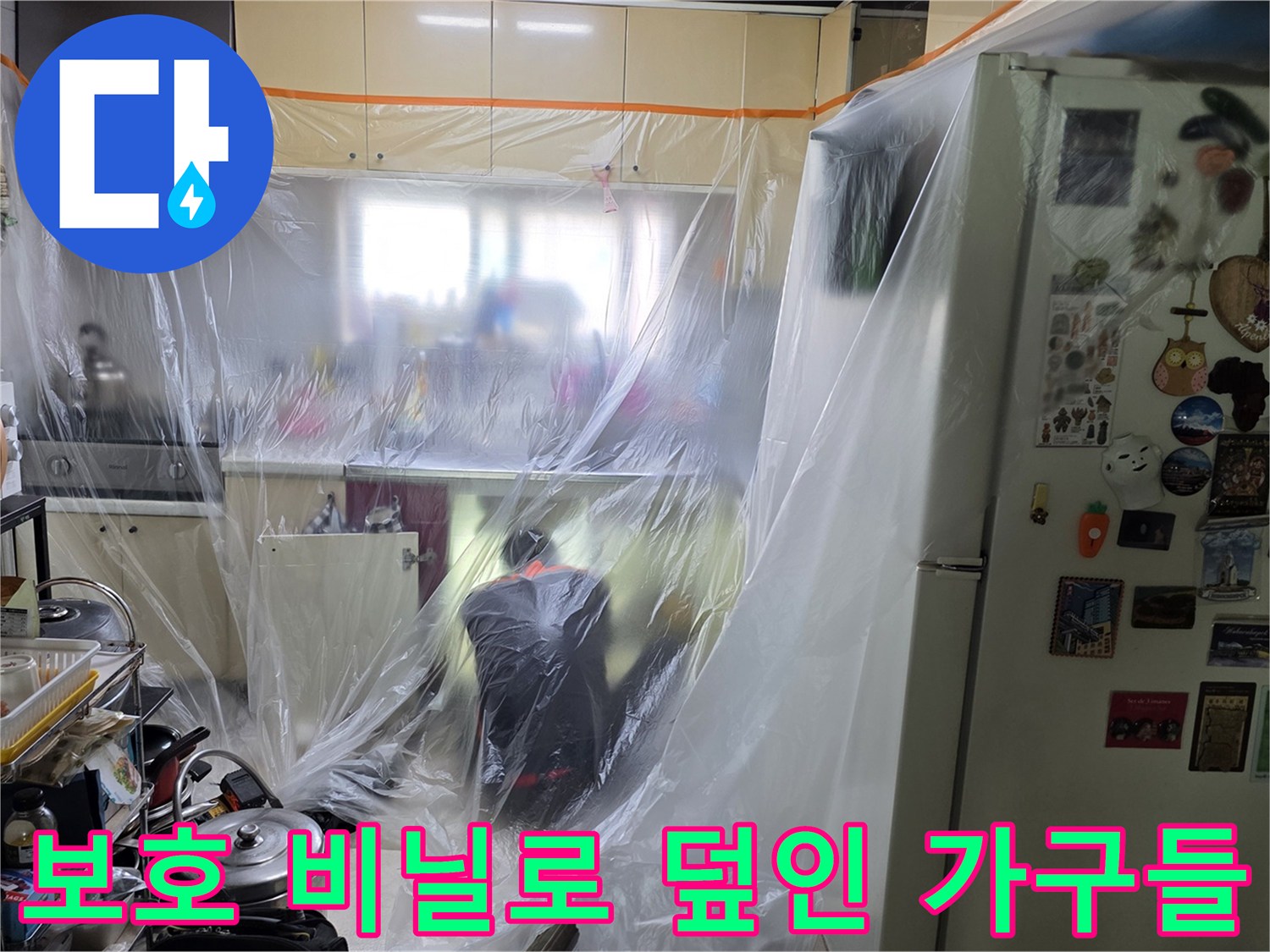 작업 중 오염을 방지하기 위해 비닐로 감싸진 주방 가구와 냉장고