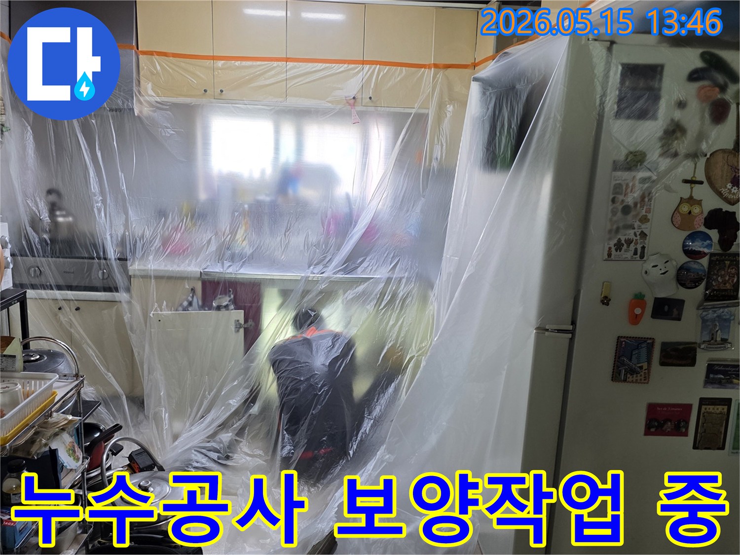전문가가 주방에서-누수 공사를 위한-보양 작업을-꼼꼼히 진행하는 장면