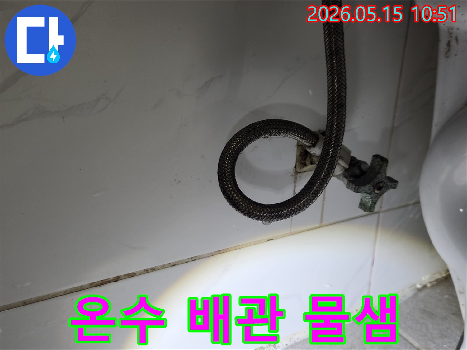 온수-배관-연결부에서-지속적으로-물방울이-떨어지는-누수-현장을-정밀하게-확인하는-사진