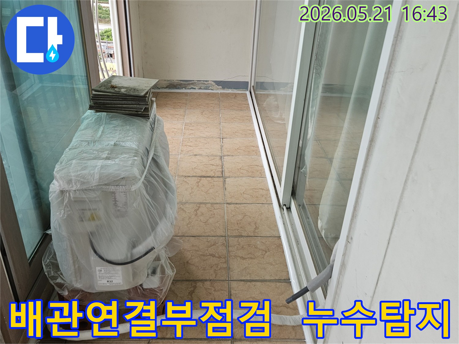 신북면-아파트-베란다의-에어컨-실외기-배관-연결-부위를-정밀하게-점검하여-누수-원인을-찾는-모습