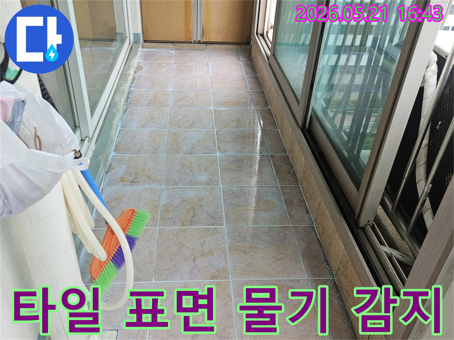 아파트 베란다 타일 표면에 물기가 맺혀 광택이 변한 모습을 보여주는 이미지-누수 전문가가 습기 원인을 분석하고 있습니다