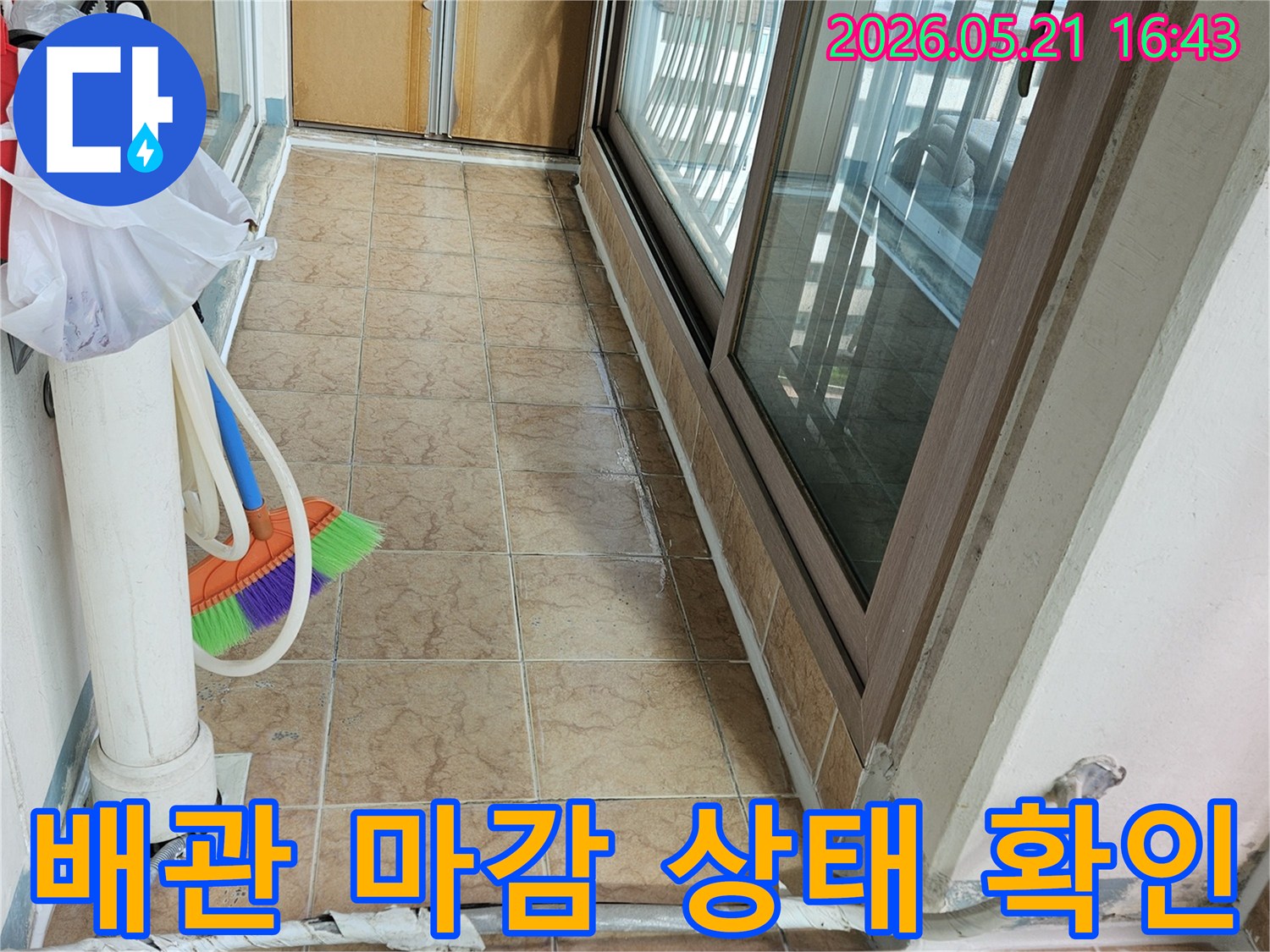 아파트 베란다의 배관 마감 상태와-타일 벽면-창문 주변을 보여주며-누수와 관련된 문제점을 점검하는 현장입니다.