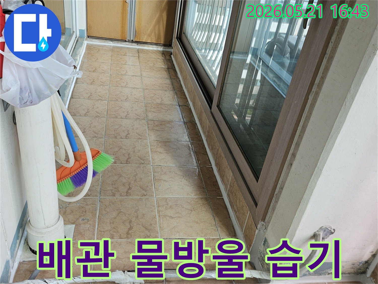 아파트 베란다의 배관 주변에 맺힌 물방울과-습기 흔적-타일 벽면을 보여주며-누수 여부를 점검하는 현장입니다.